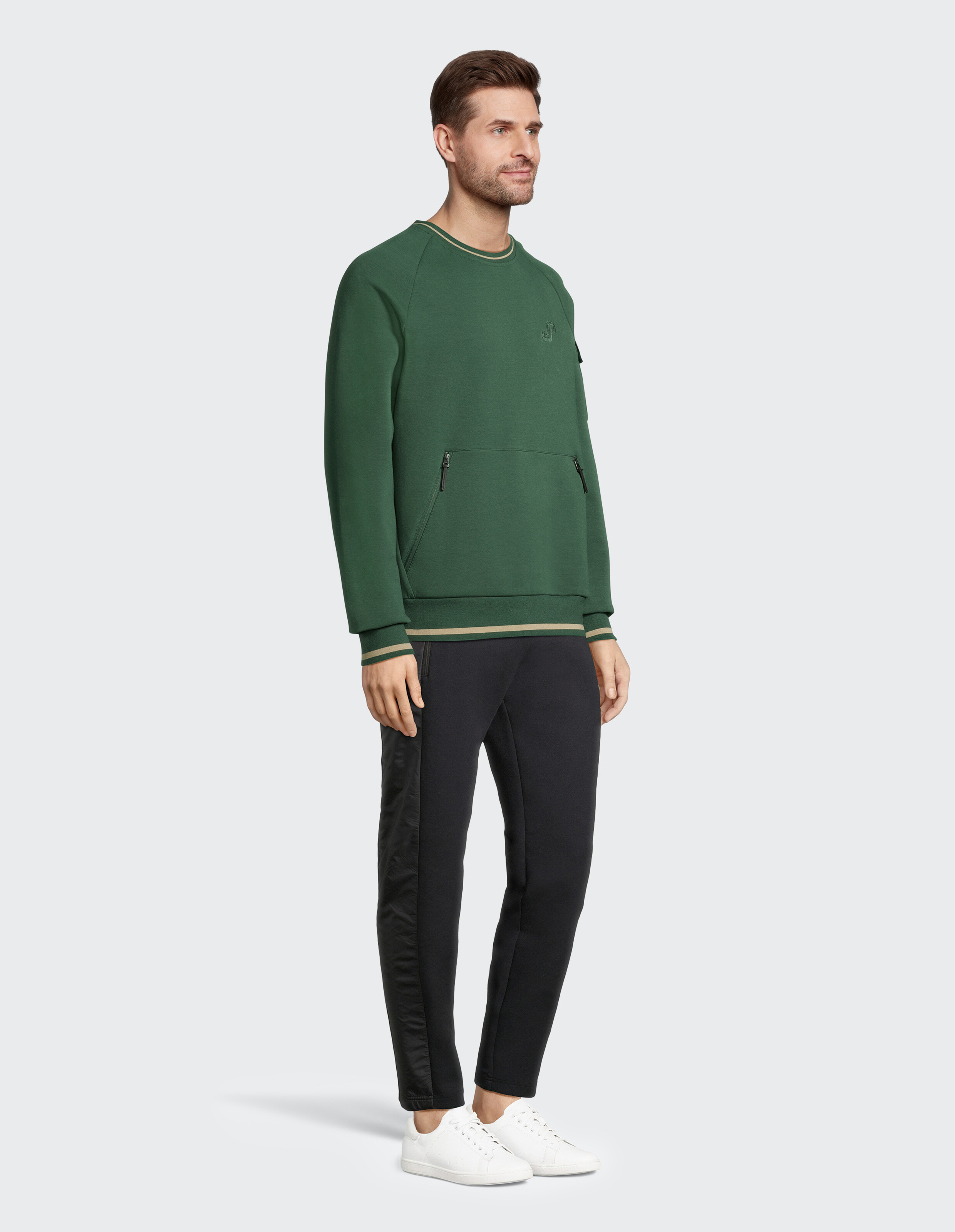Mann in einem grünen Sweatshirt und schwarzen Jogginghosen, perfekt für Freizeitkleidung.