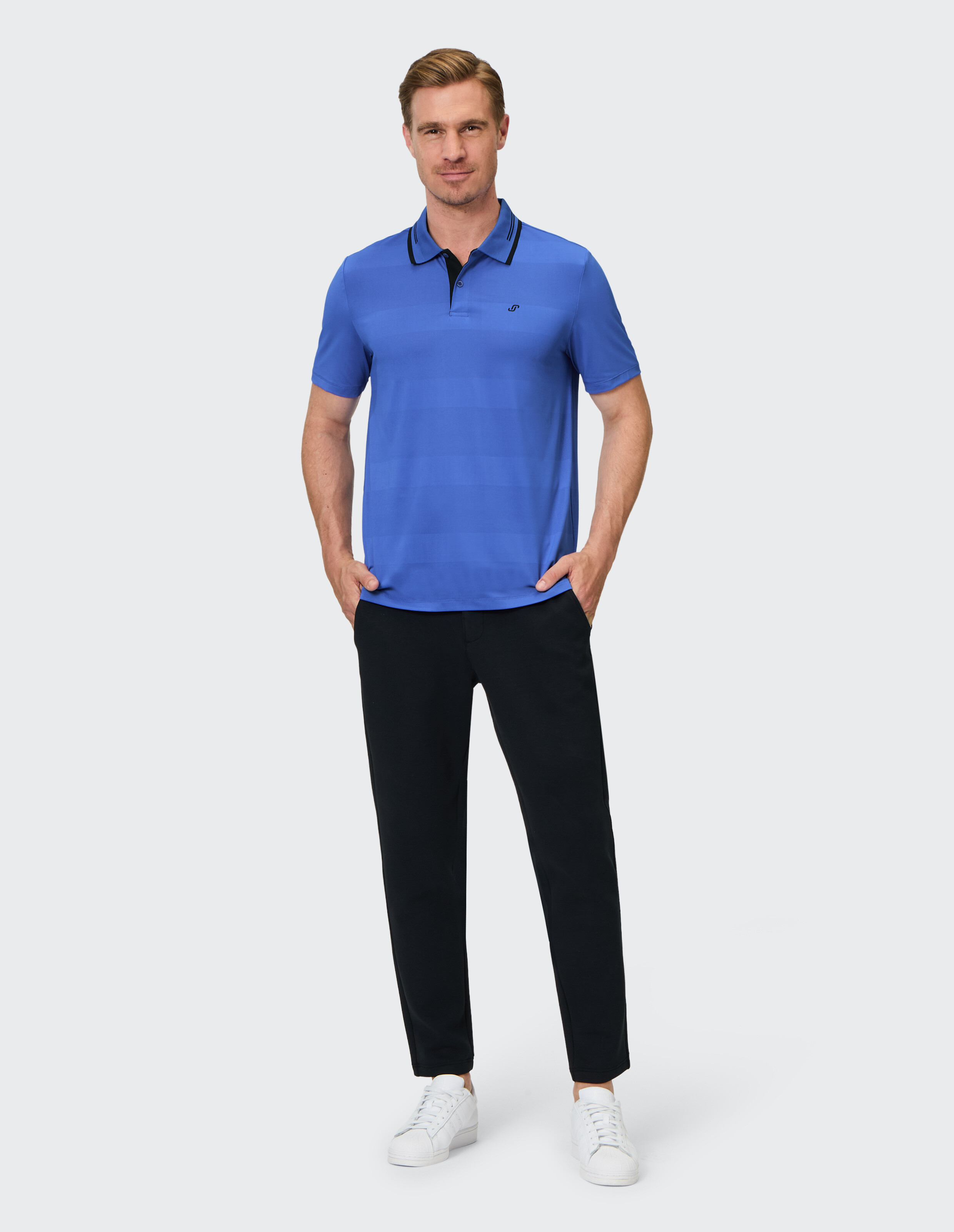 Mann trägt ein blau gestreiftes Poloshirt und eine schwarze Freizeithose für einen stilvollen Look.