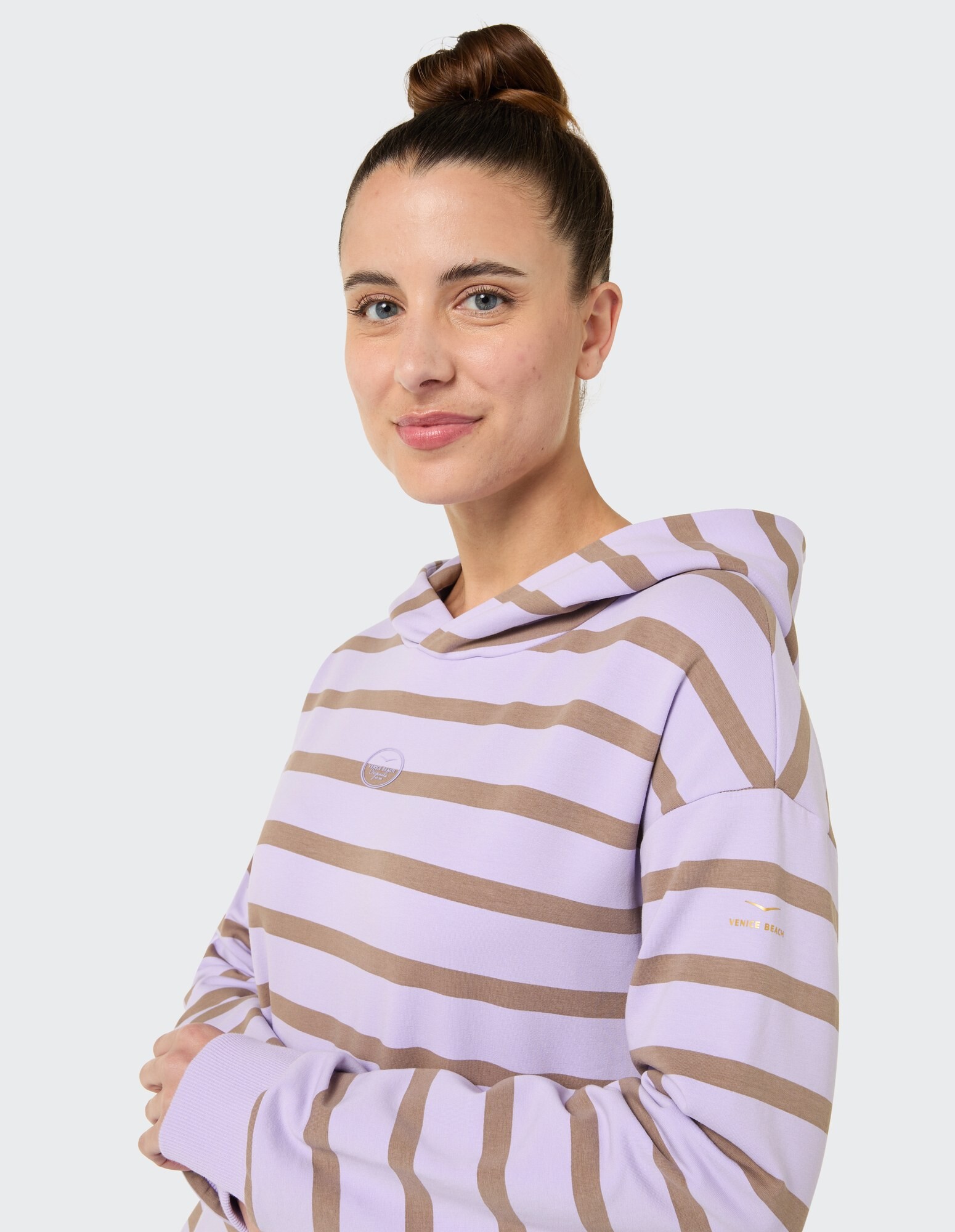 Frau in einem gestreiften lavendelfarbenen Kapuzenpullover, perfekt für Freizeitkleidung und Faulenzen.