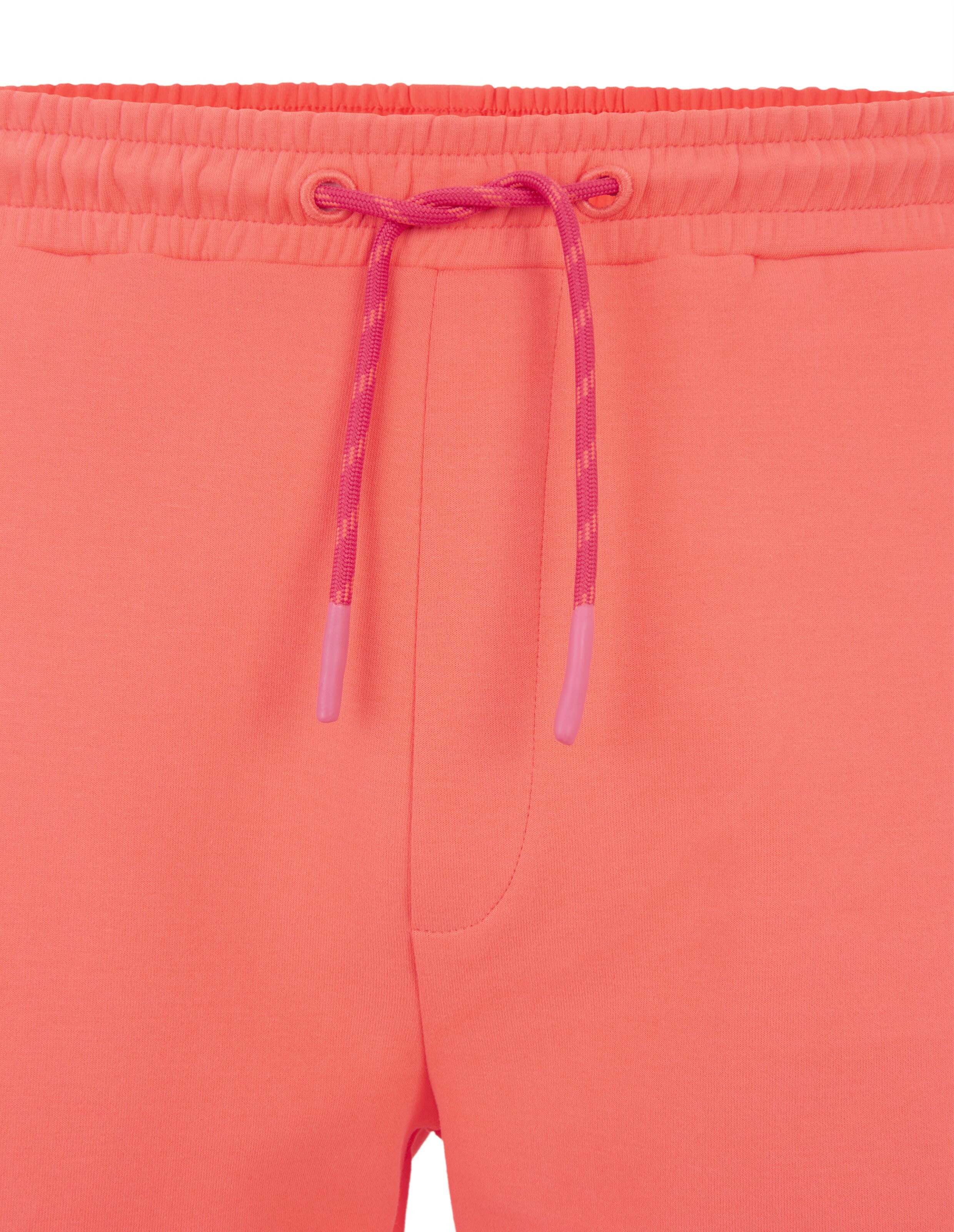 Nahaufnahme einer korallenrosa Lounge-Jogginghose mit verstellbarem Kordelzug in der Taille.