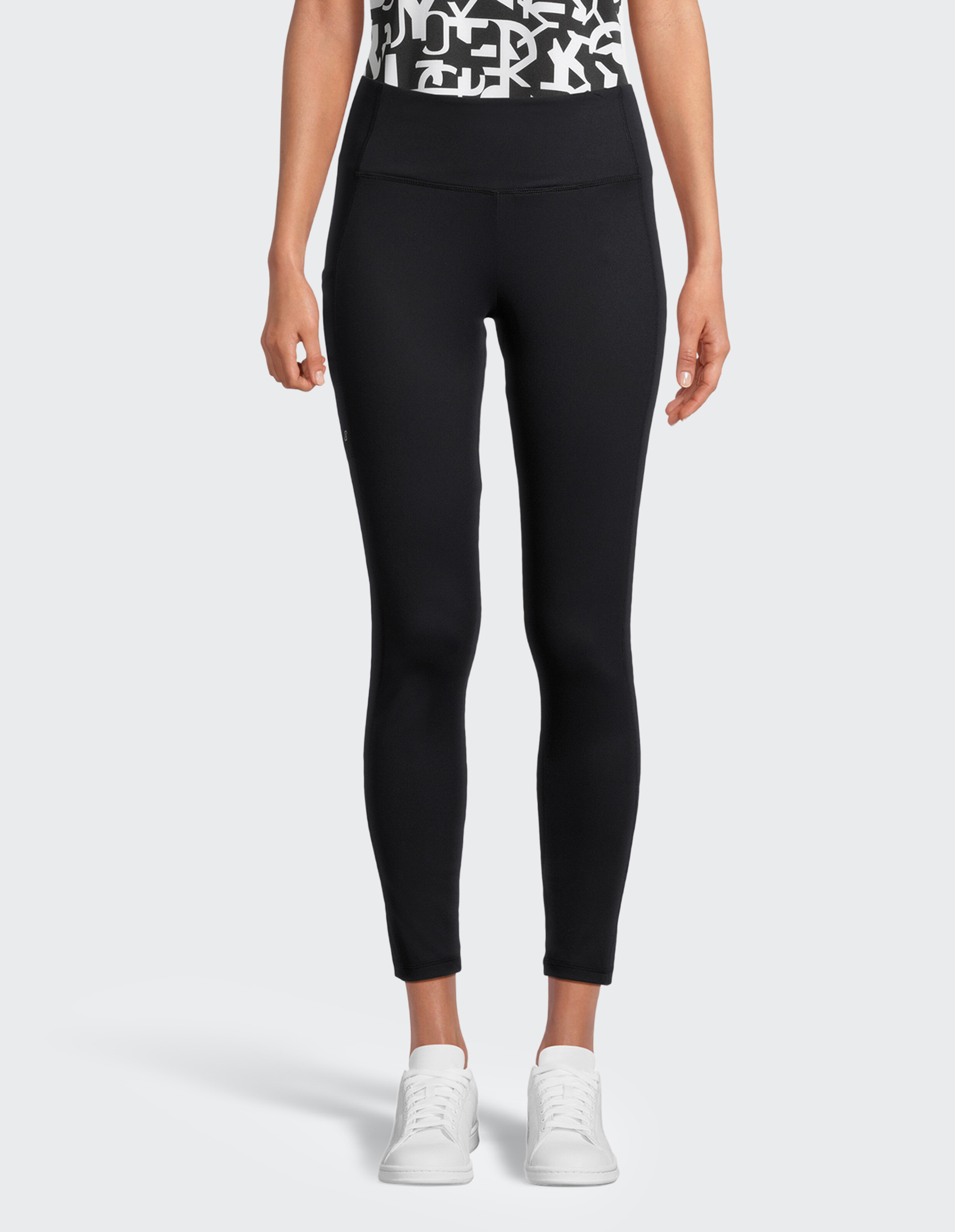 Frau trägt schwarze Leggings mit hohem Bund, perfekt für lässige, bequeme Alltagskleidung.