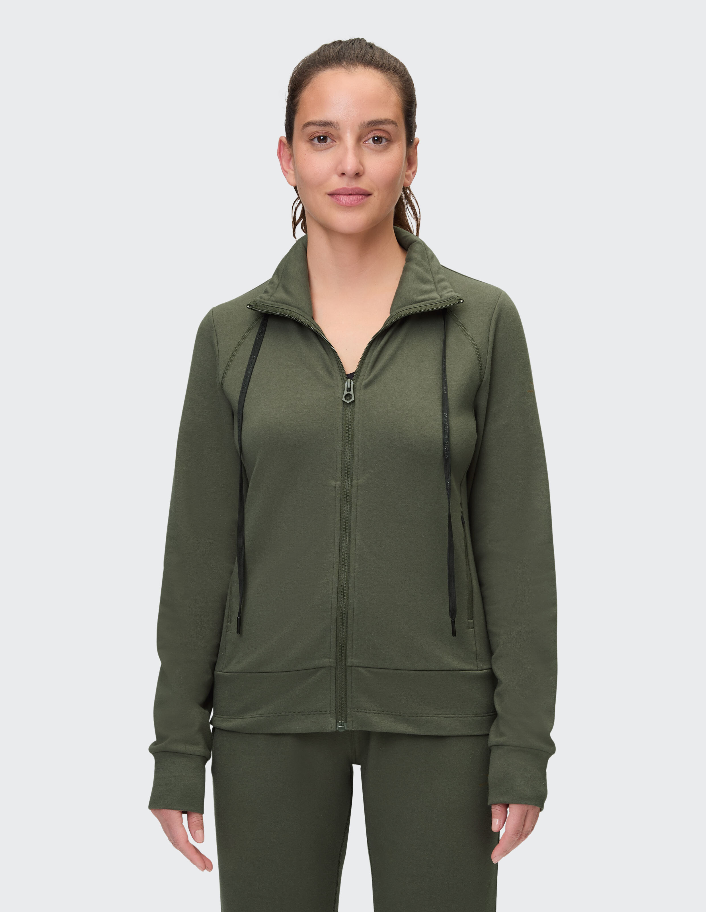 Frau trägt eine gemütliche olivgrüne Sweatjacke mit Reißverschluss von Venice Beach Florence.