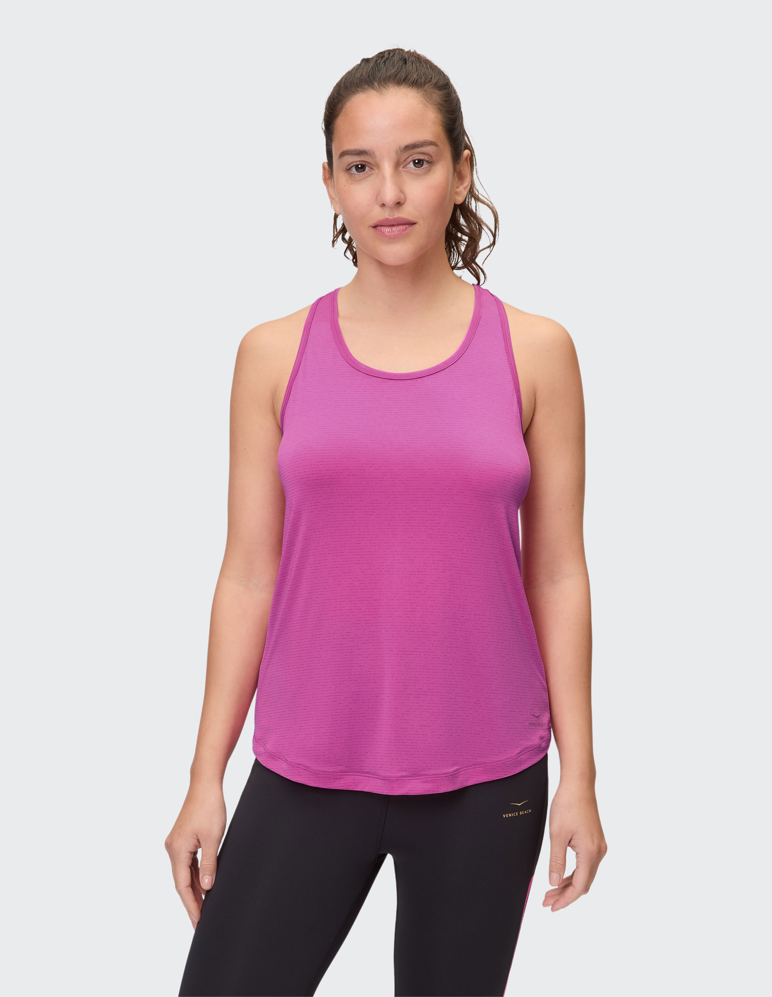 Frau trägt ein rosa Racerback-Tanktop für lässige Sport- oder Loungekleidung.