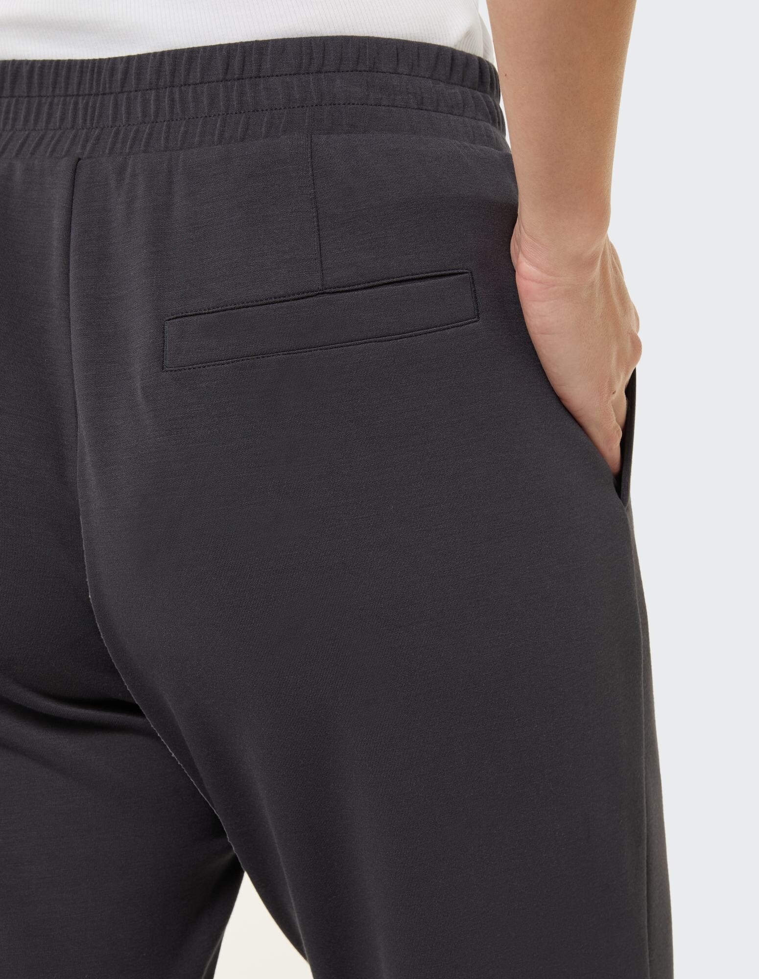 Nahaufnahme einer dunkelgrauen Freizeithose mit Gesäßtaschendetail.