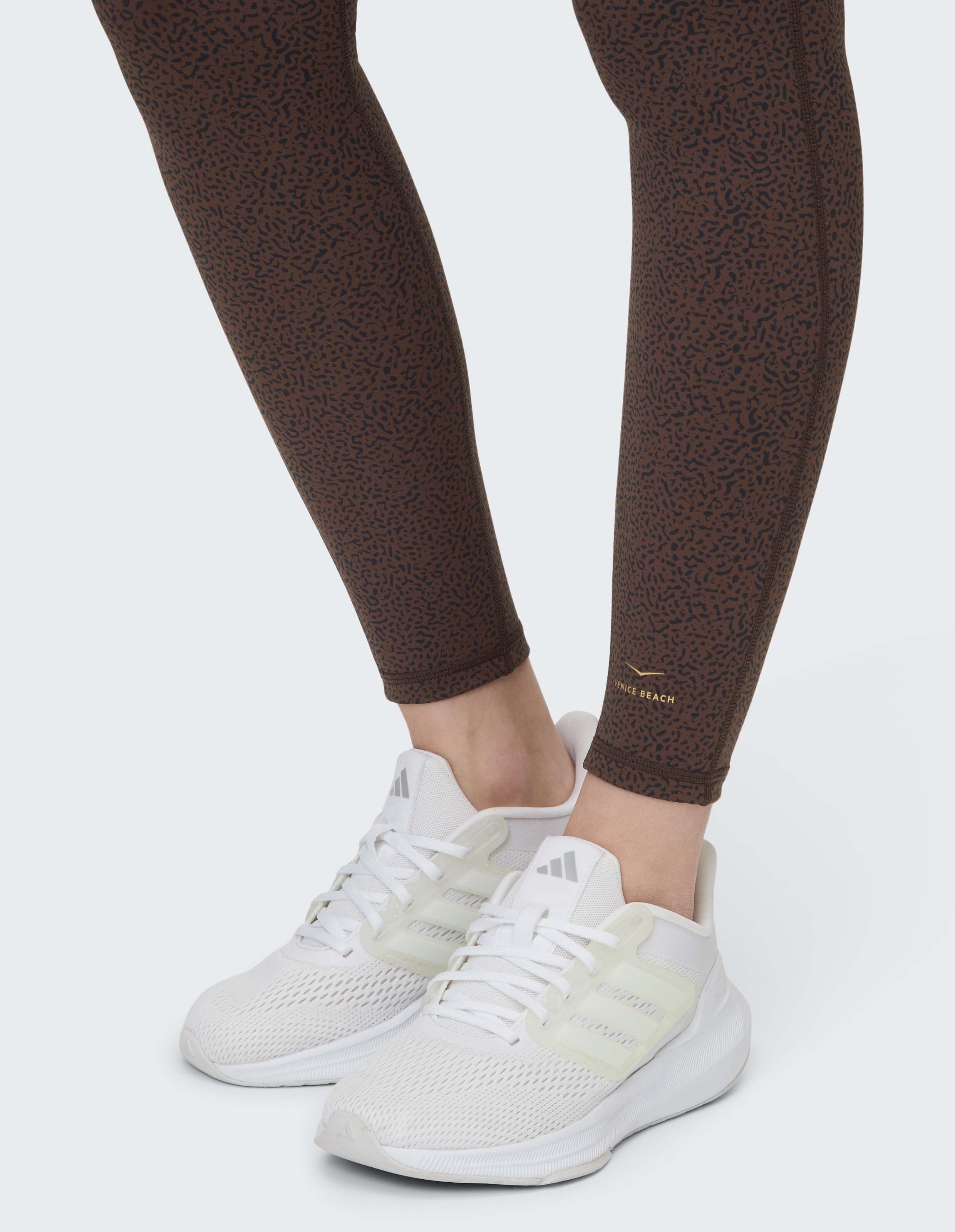 Venice Beach Keeva-Strumpfhose in Braun mit dezentem Muster und weißen Sneakers.