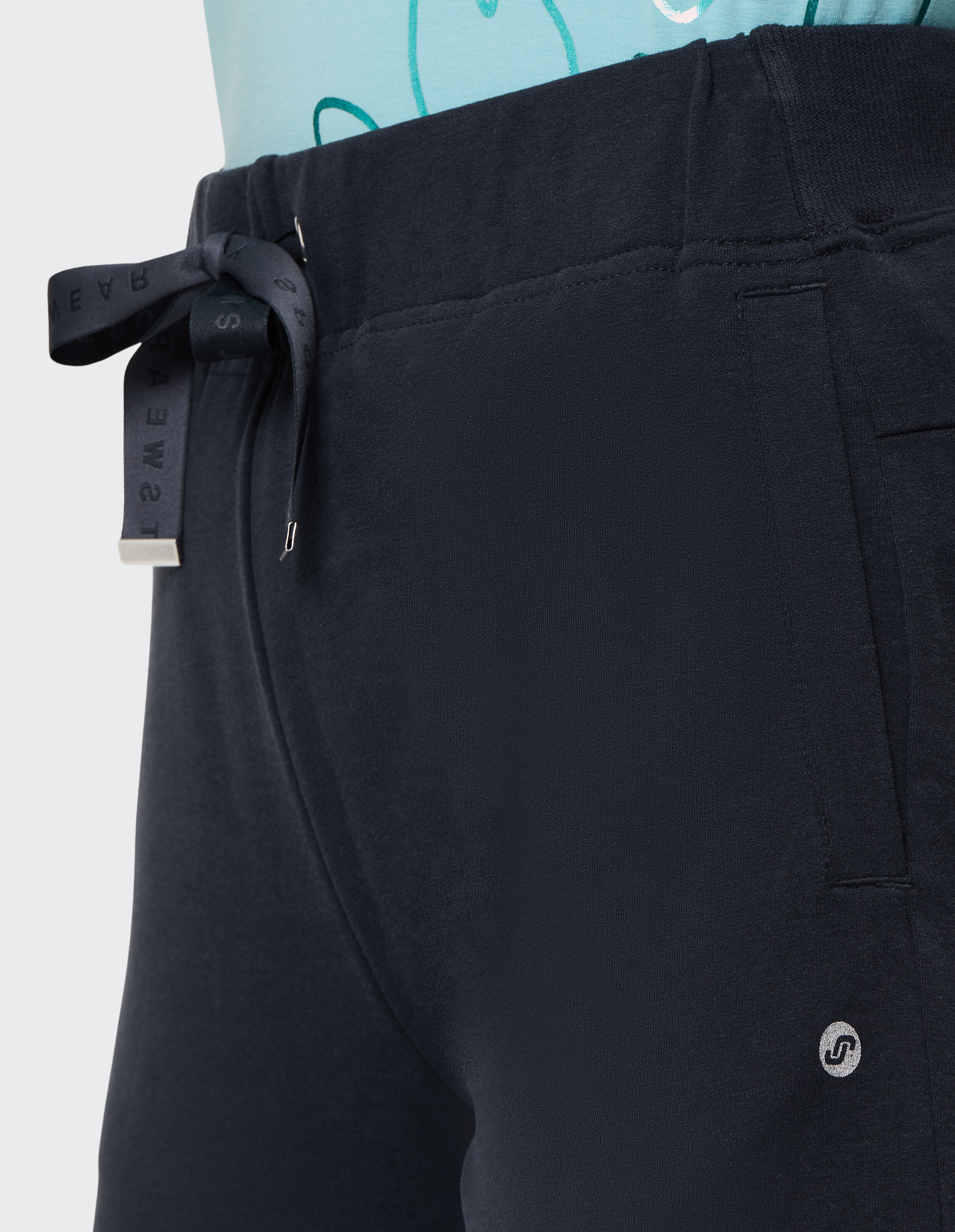 Nahaufnahme einer marineblauen Freizeitshorts mit Kordelzug und Logodetail.