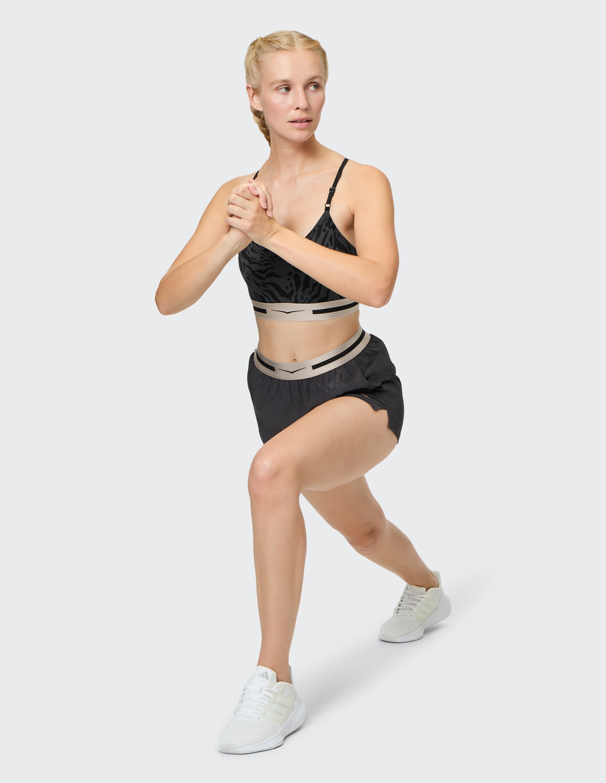 Frau trägt einen schwarzen Sport-BH „Venice Beach Top“ von Oakley und passende Shorts.