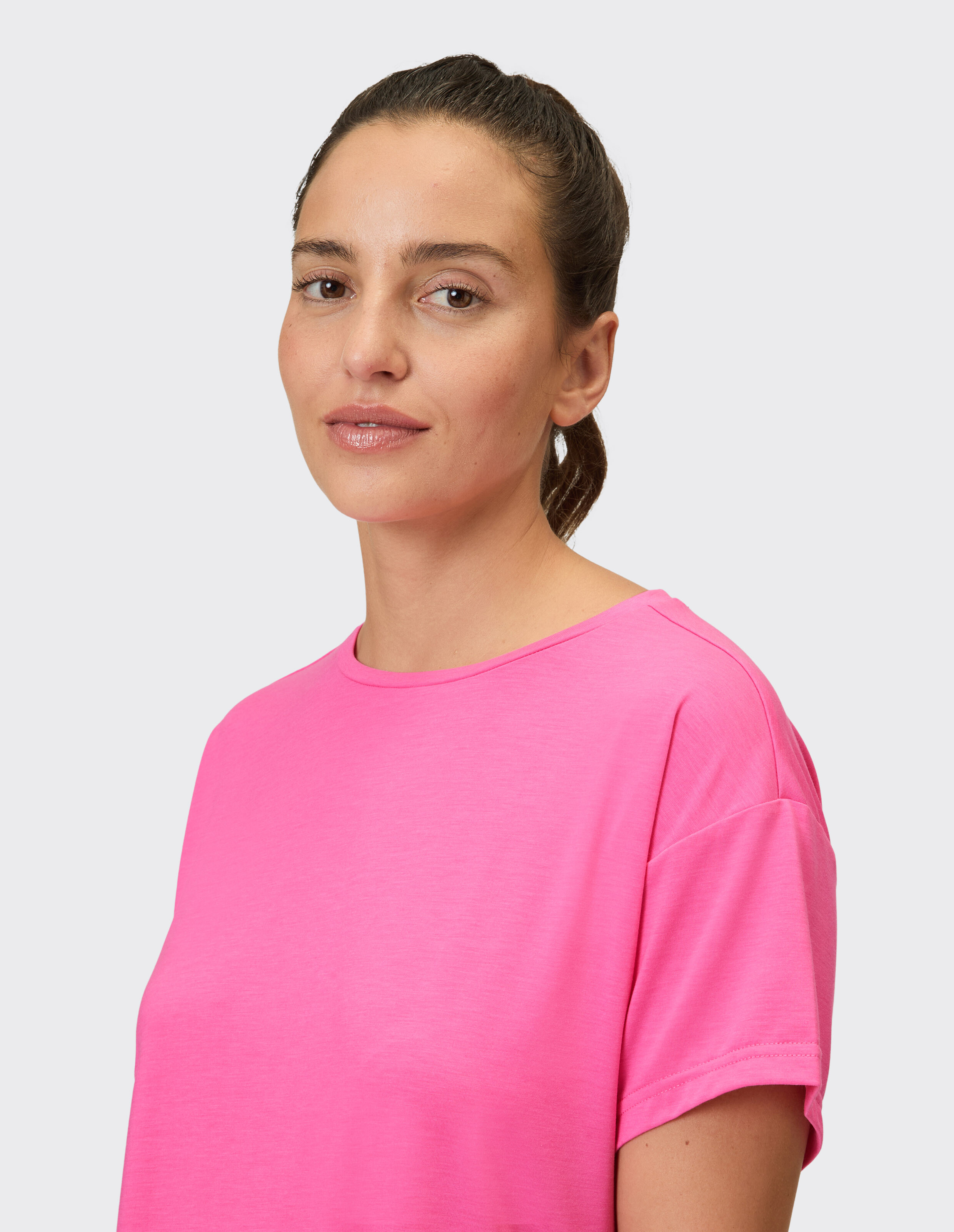 Das Model trägt ein gemütliches rosa Freizeit-T-Shirt mit kurzen Ärmeln.