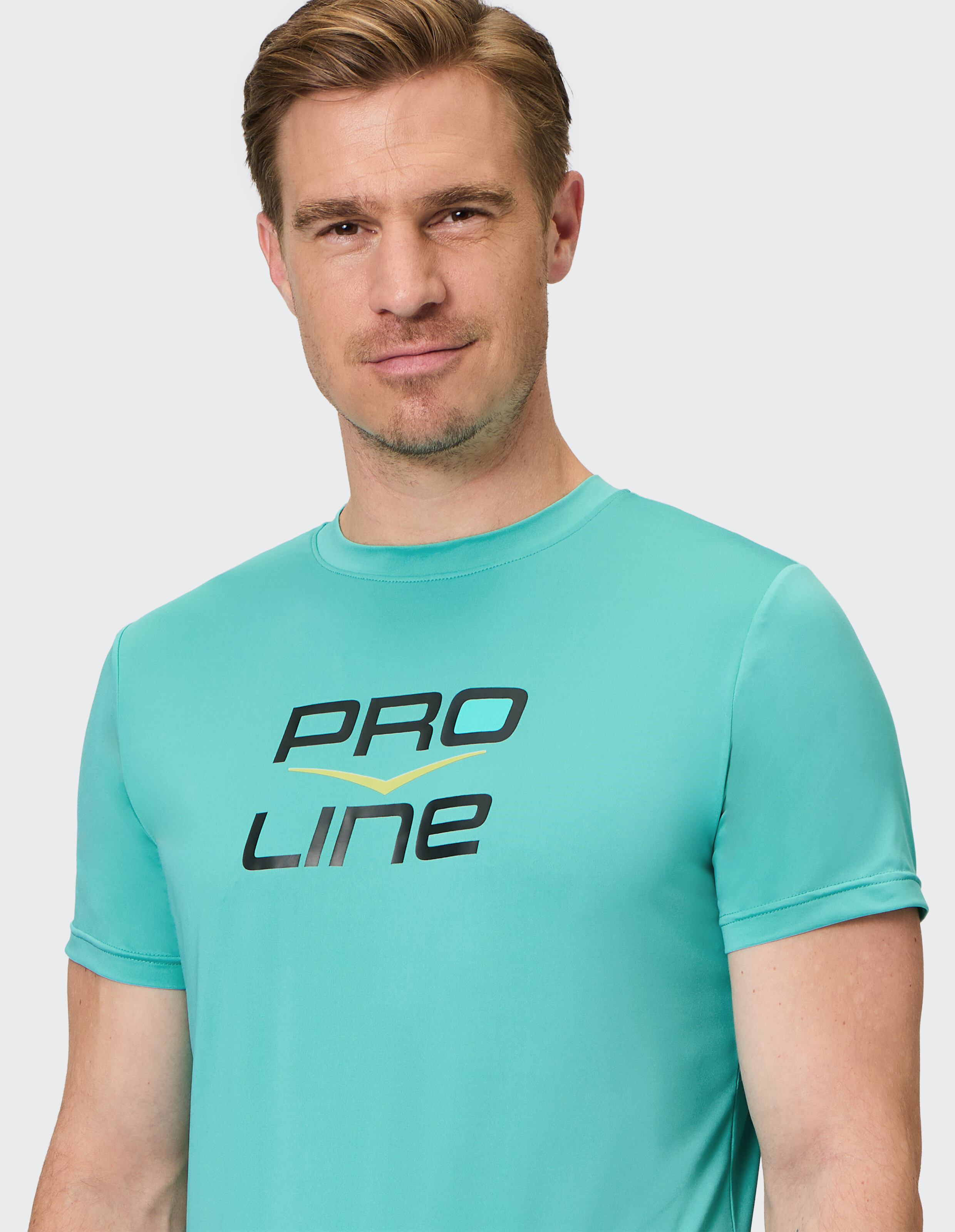 Mann trägt ein türkisfarbenes, kurzärmeliges Freizeit-T-Shirt mit Pro Line-Logoaufdruck.