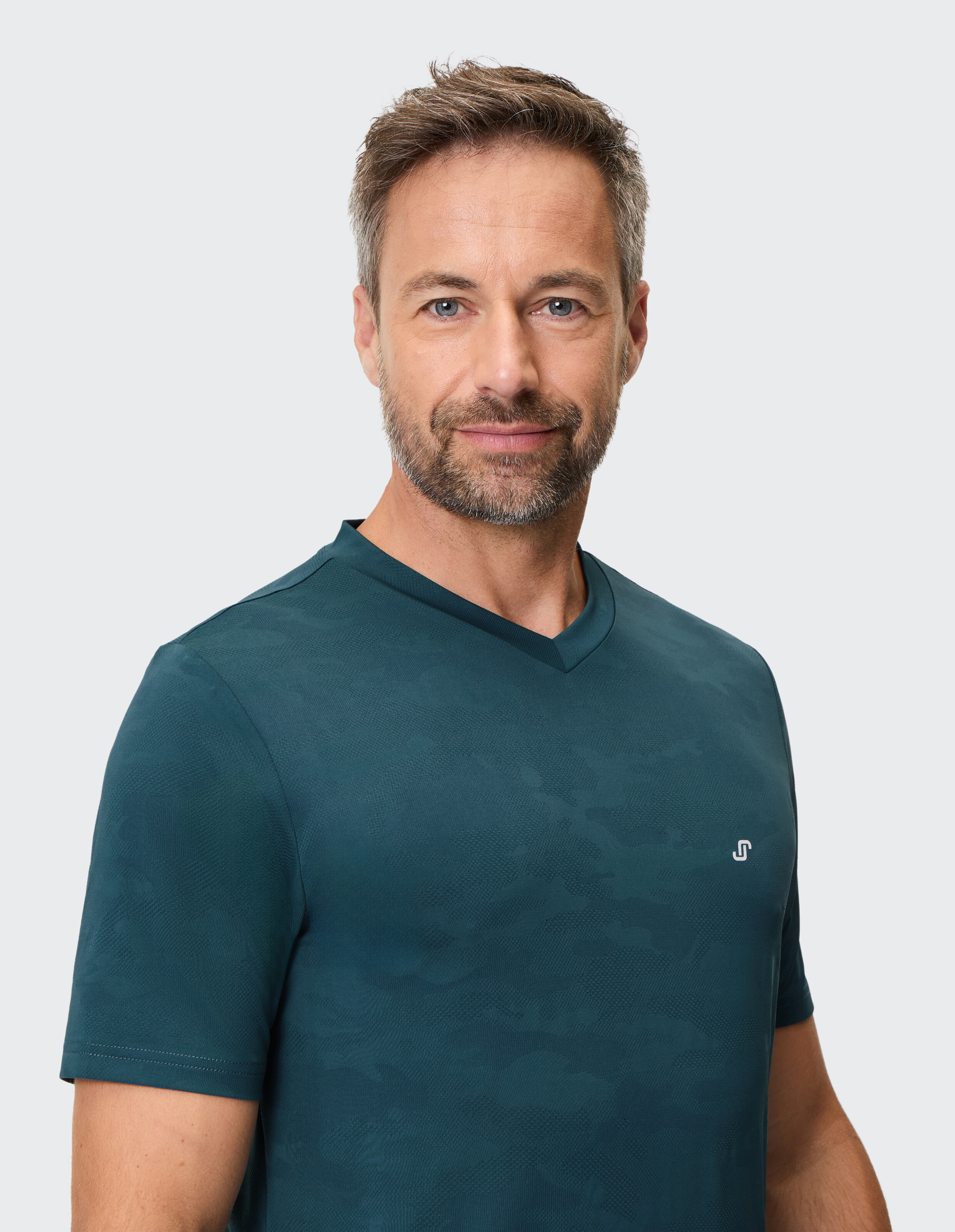 Mann trägt ein dunkelgrünes Freizeit-T-Shirt mit V-Ausschnitt und dezentem Muster.