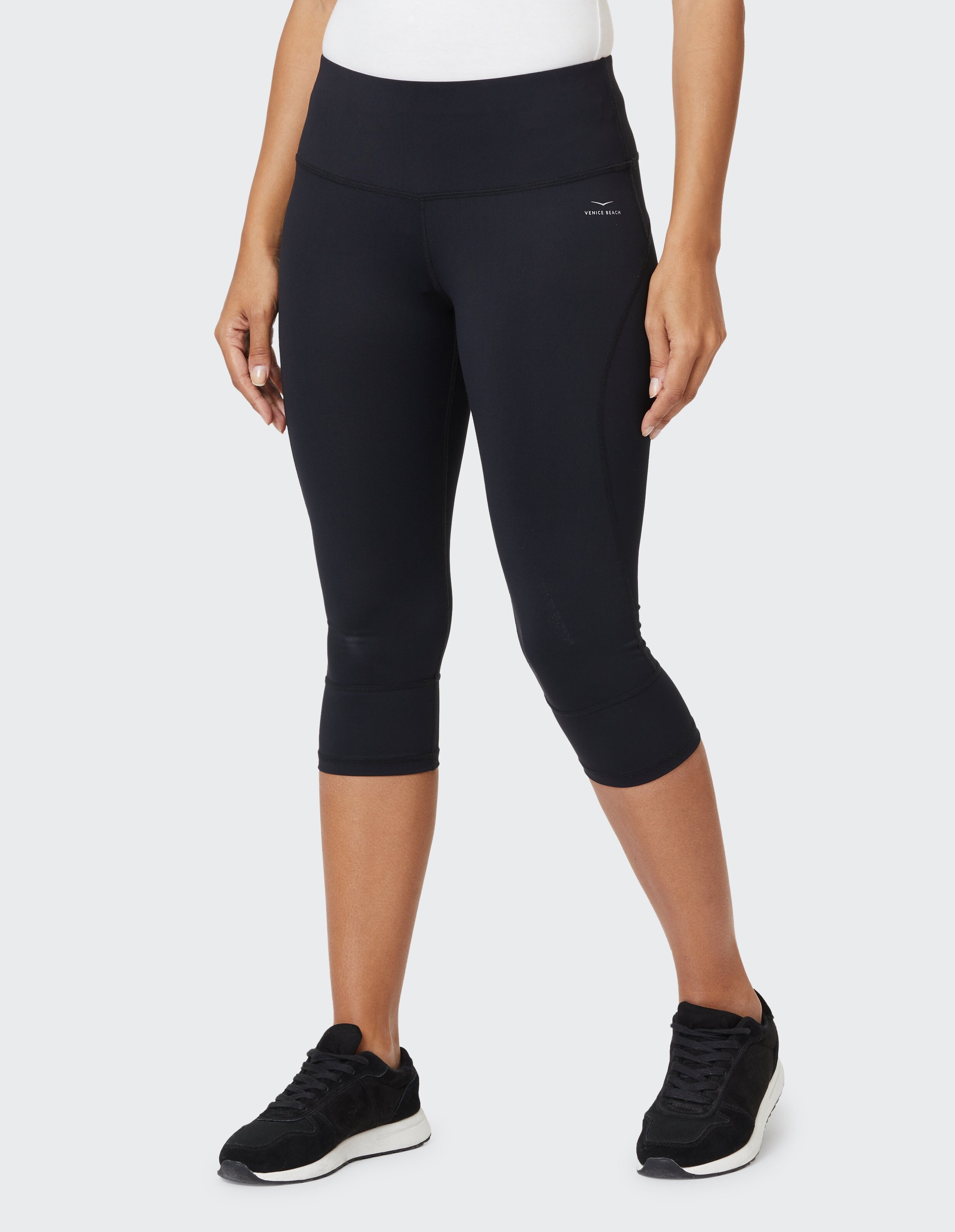 Frau trägt schwarze Capri-Leggings für einen lässigen, bequemen und aktiven Lebensstil.