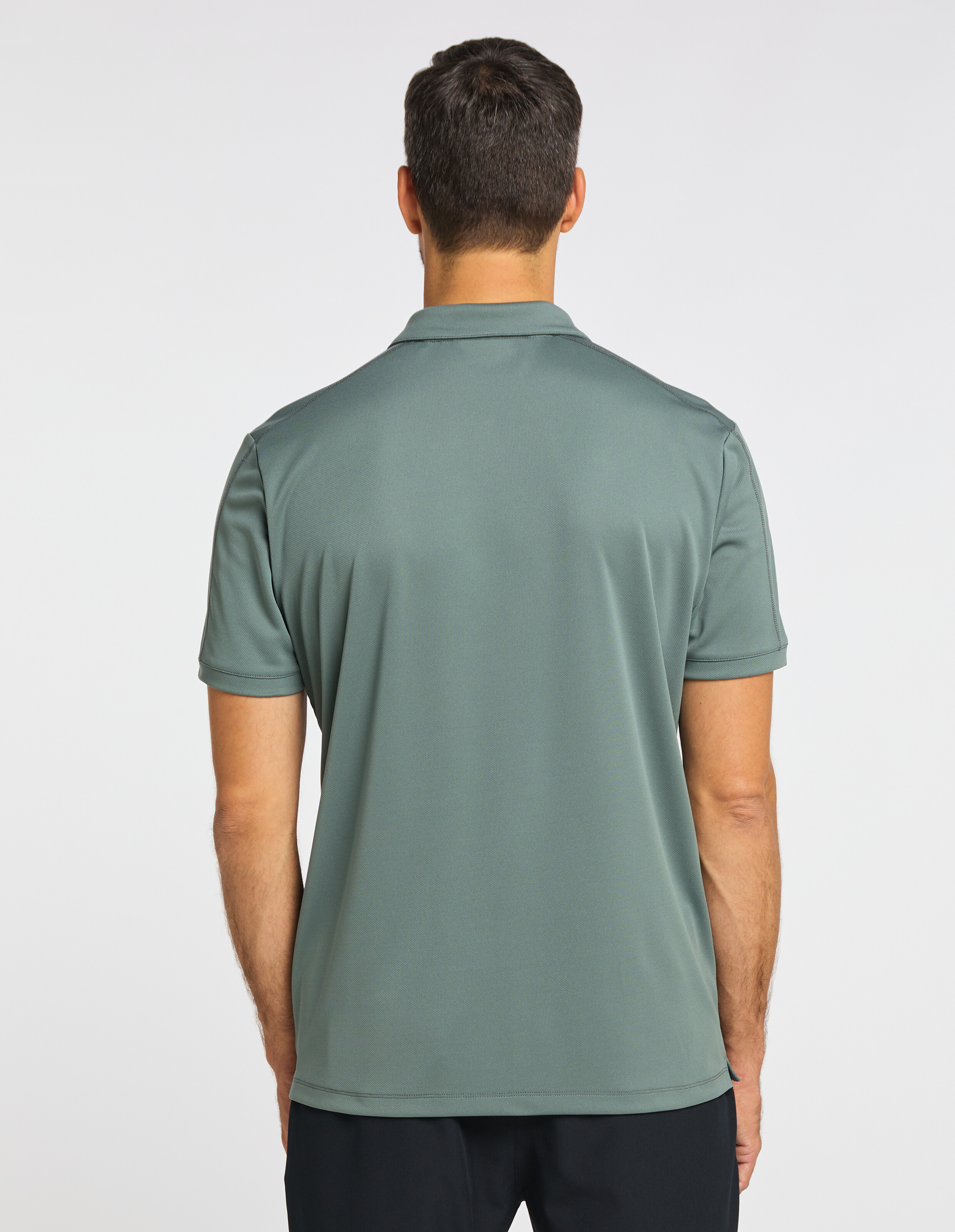 Rückansicht eines Mannes, der ein salbeigrünes Freizeit-Poloshirt für einen bequemen, eleganten Look trägt.