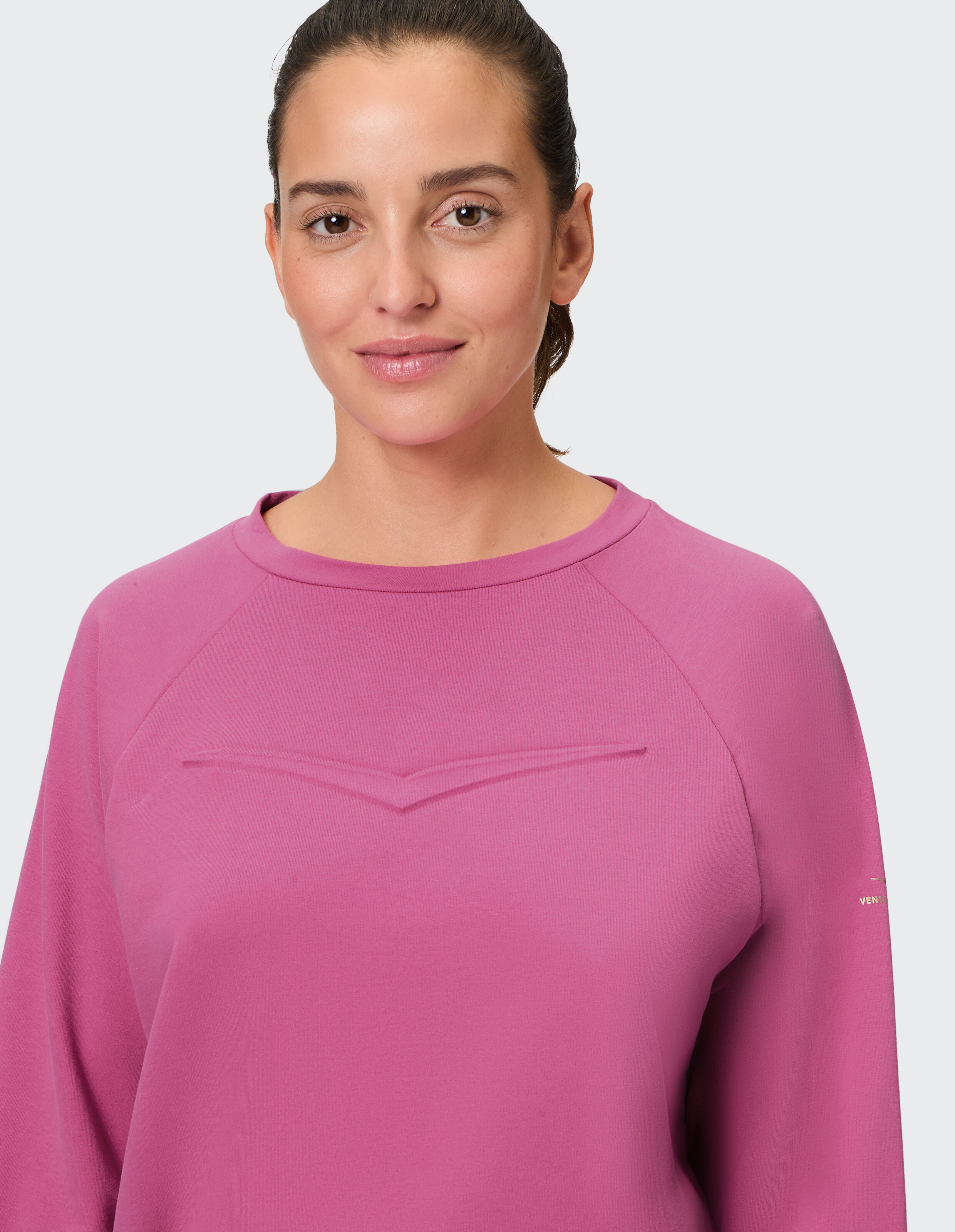 Frau trägt ein gemütliches rosafarbenes ELBSAND-Freizeit-Sweatshirt mit Raglanärmeln.