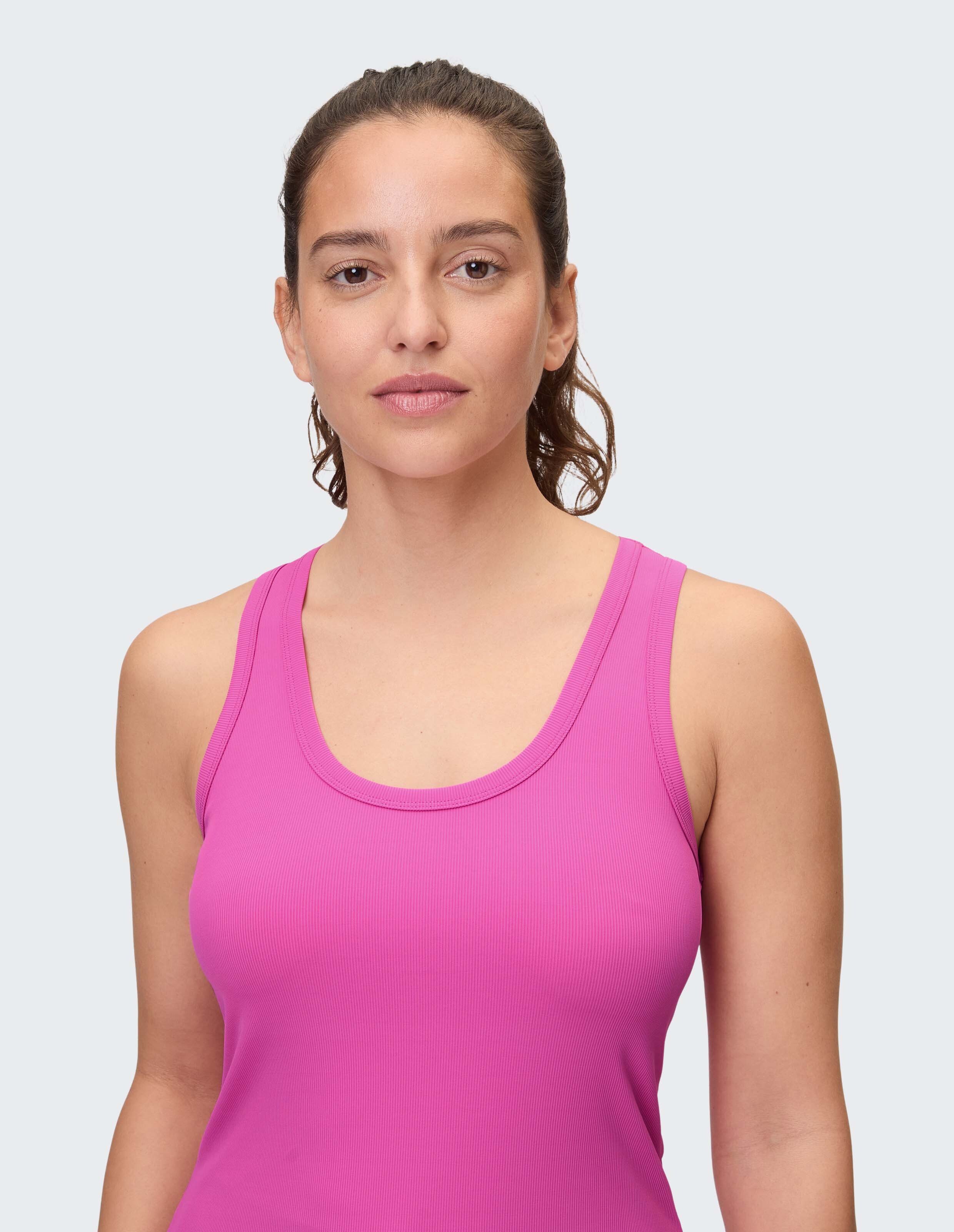 Frau trägt ein bequemes, geripptes rosa Tanktop zum entspannten Entspannen.