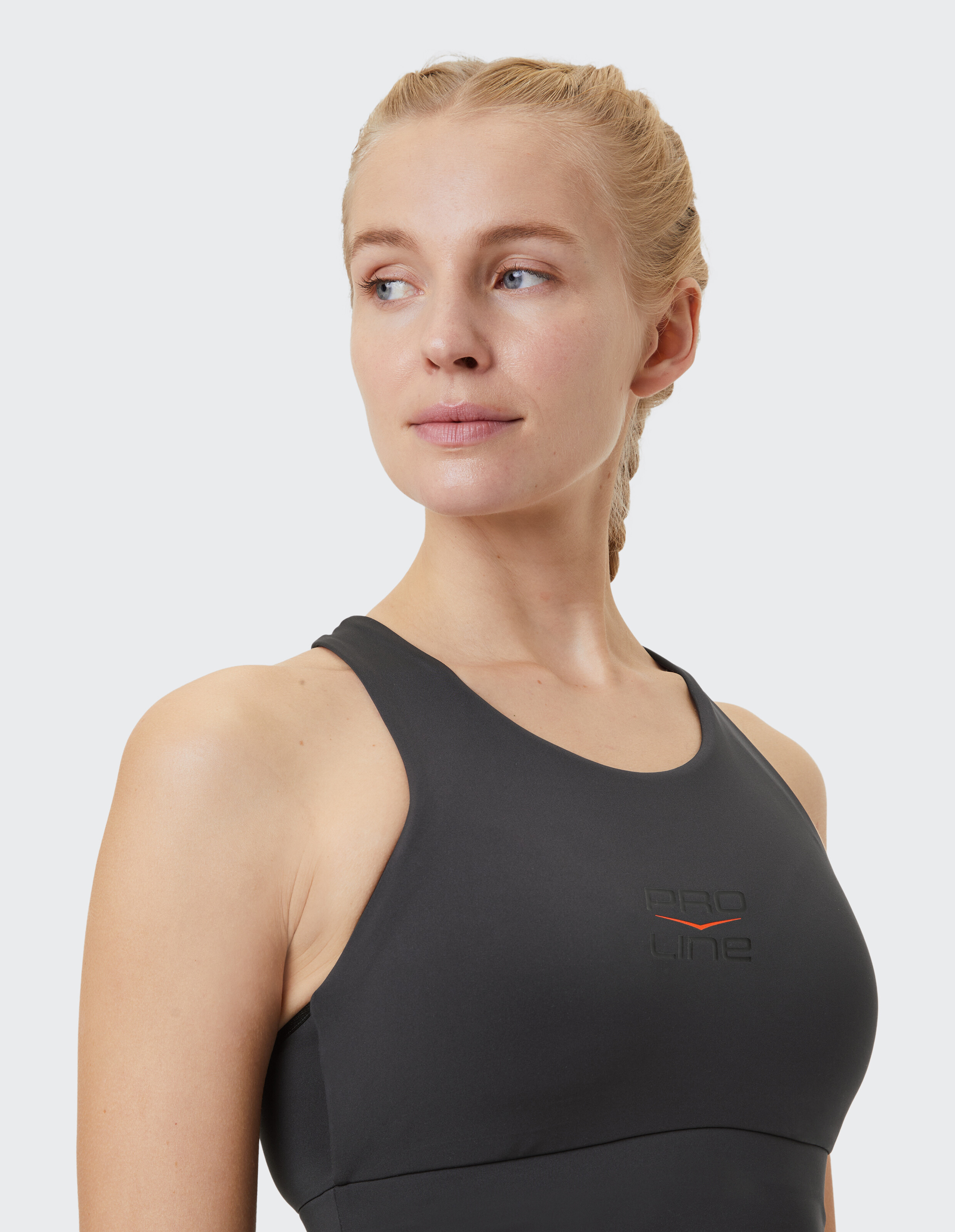 Nahaufnahme einer Frau in einem schwarzen Sport-Tanktop mit Logo, ideal für Freizeitkleidung.