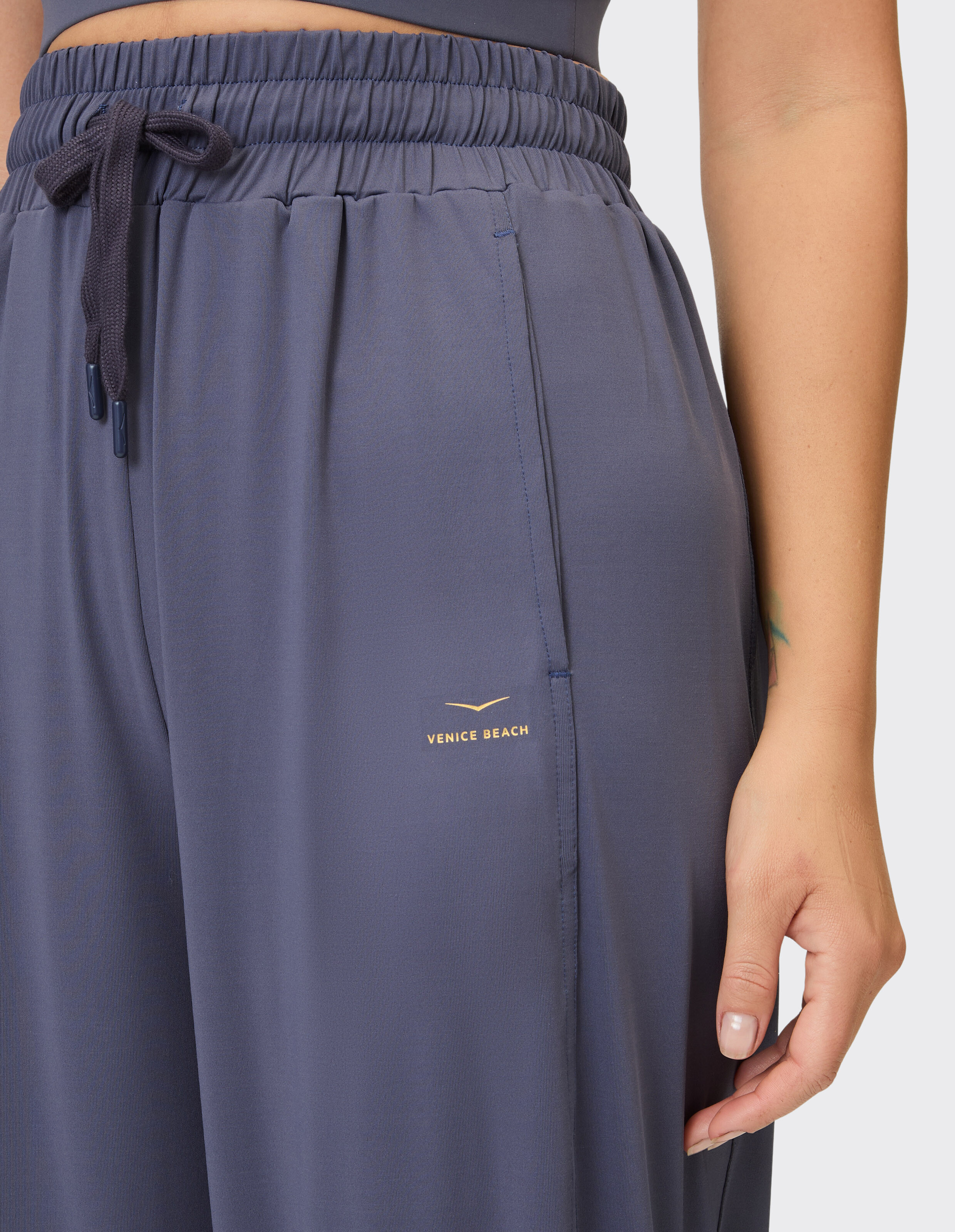 Nahaufnahme einer dunkelblauen Lounge-Hose mit elastischem Bund und Venice Beach-Logo.