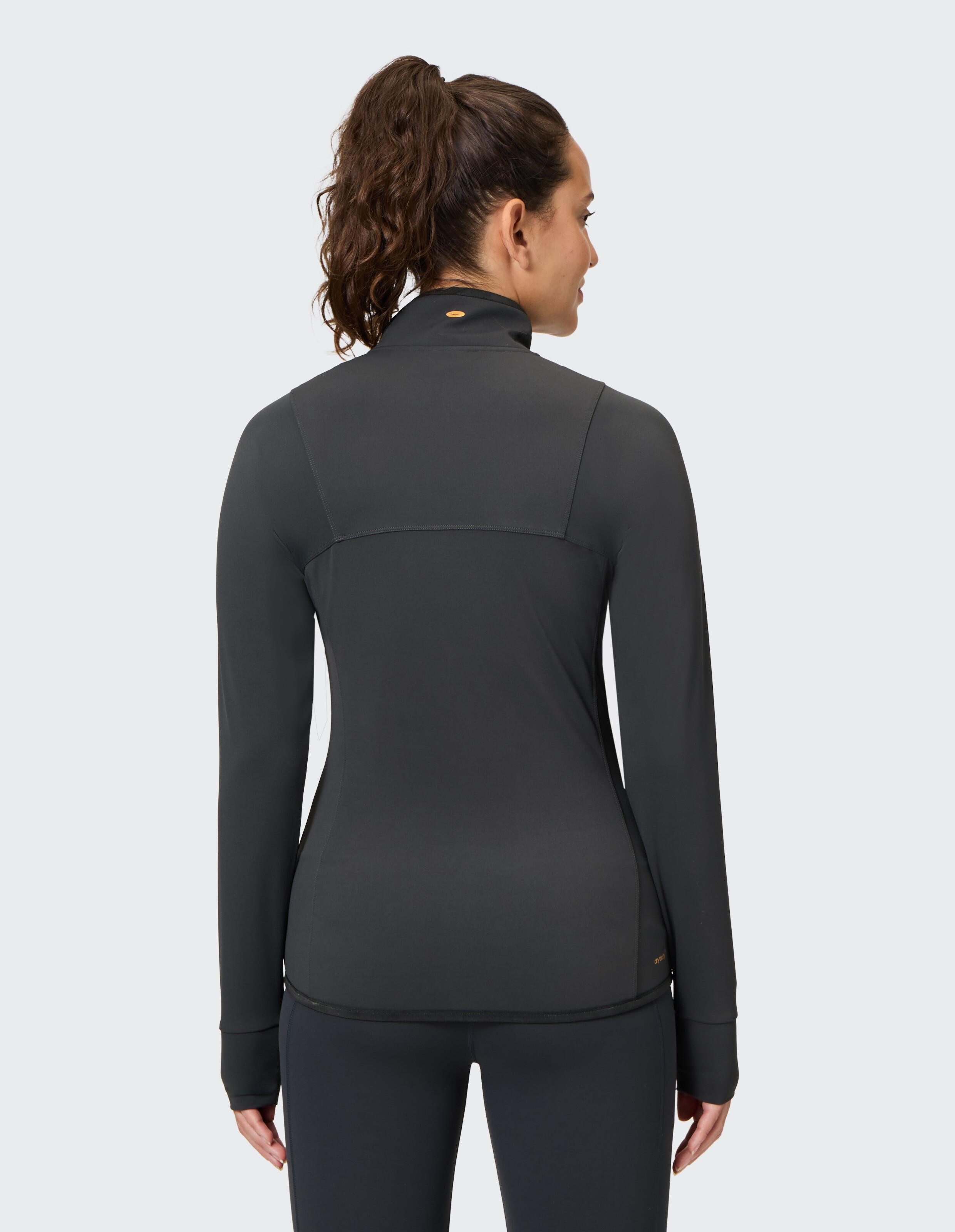 Rückansicht einer Frau, die eine dunkelgraue Funktionsjacke von Venice Beach Beven trägt.