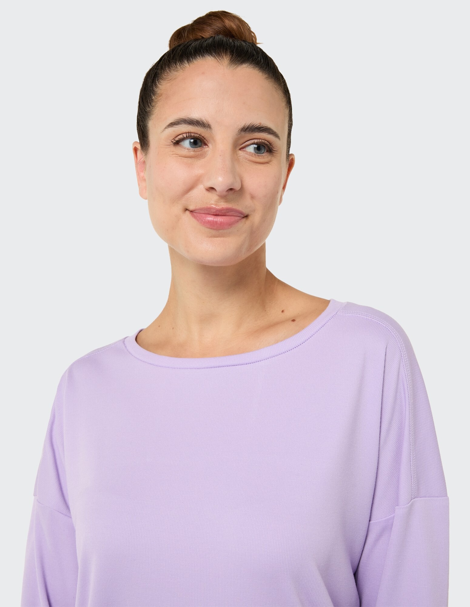 Lächelnde Frau in einem gemütlichen lavendelfarbenen Langarm-Top, perfekt für Freizeitkleidung.