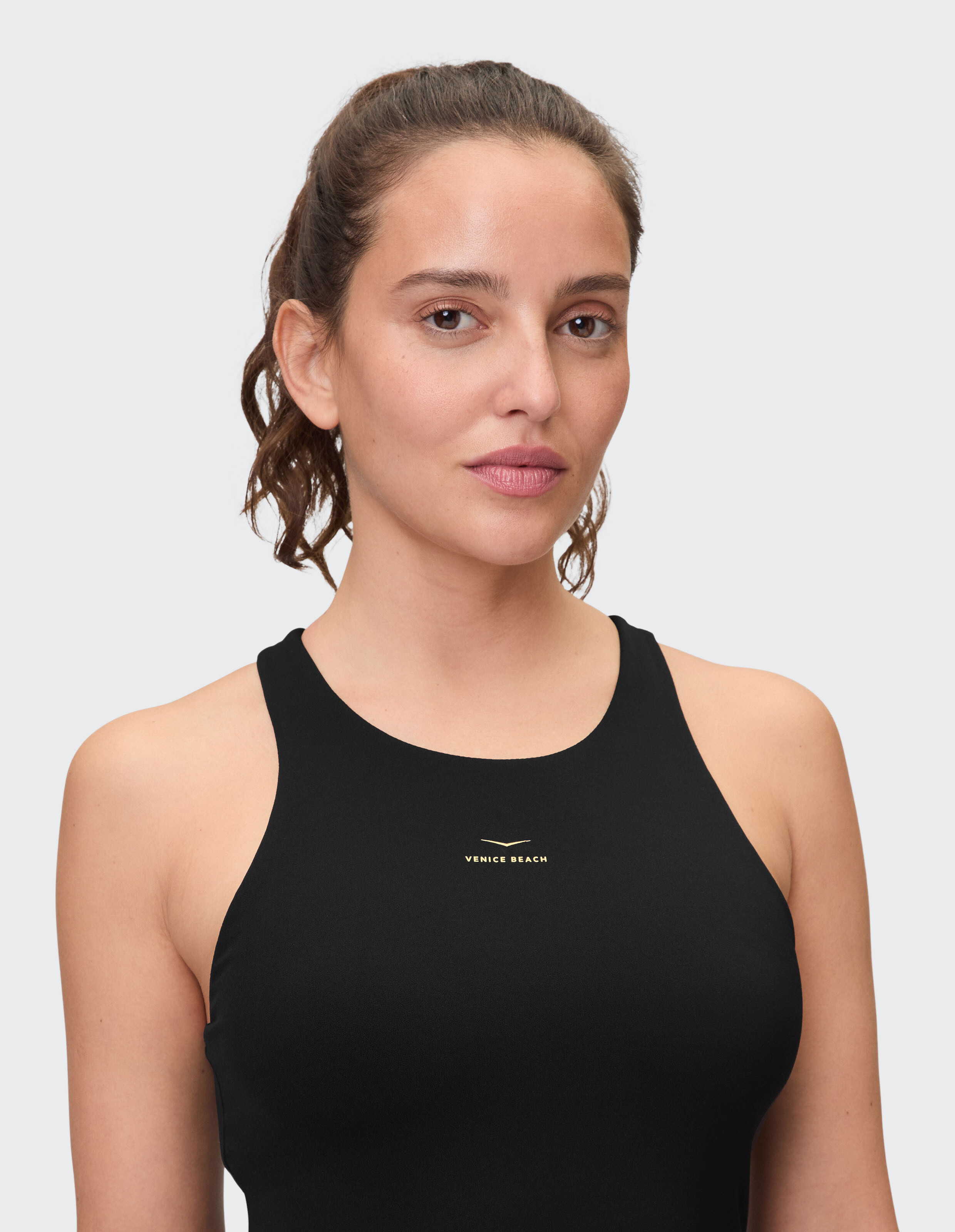 Nahaufnahme einer Frau in einem schwarzen ärmellosen Top mit „Venice Beach“-Logo.