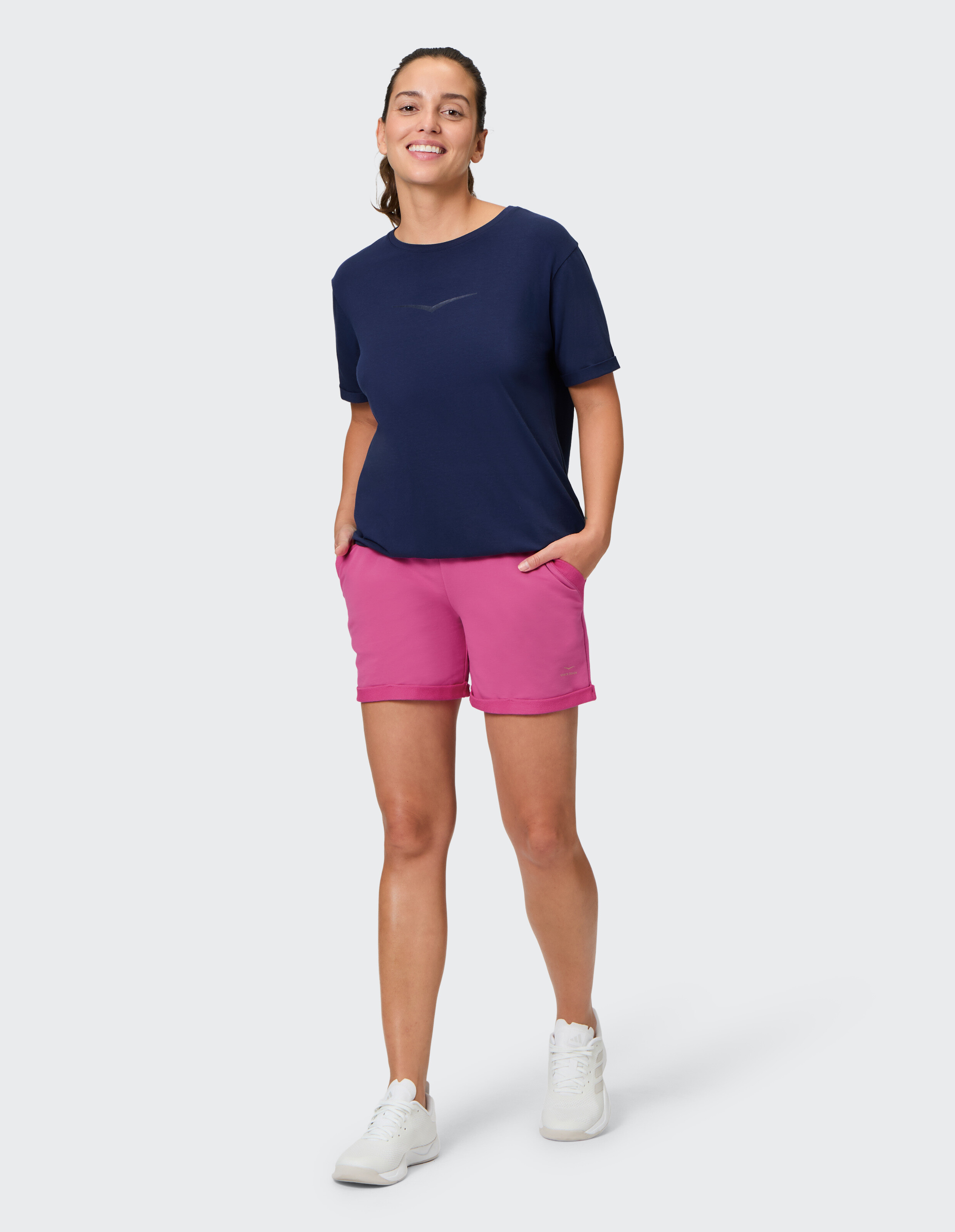 Frau in dunkelblauem T-Shirt und rosa Shorts, perfekt für lässige Sommerausflüge.