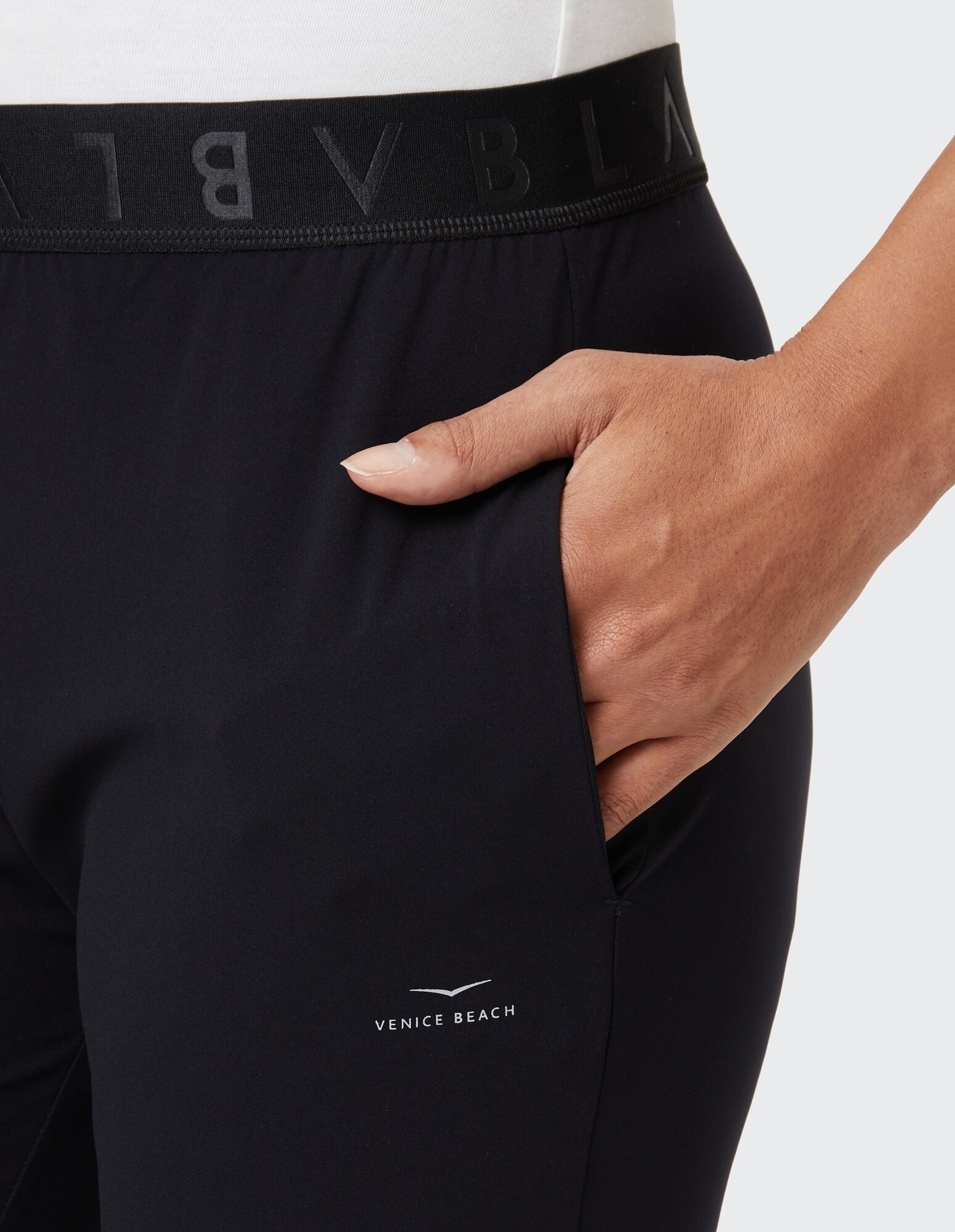 Nahaufnahme einer schwarzen Freizeithose mit Venice Beach-Logo und elastischem Bund.