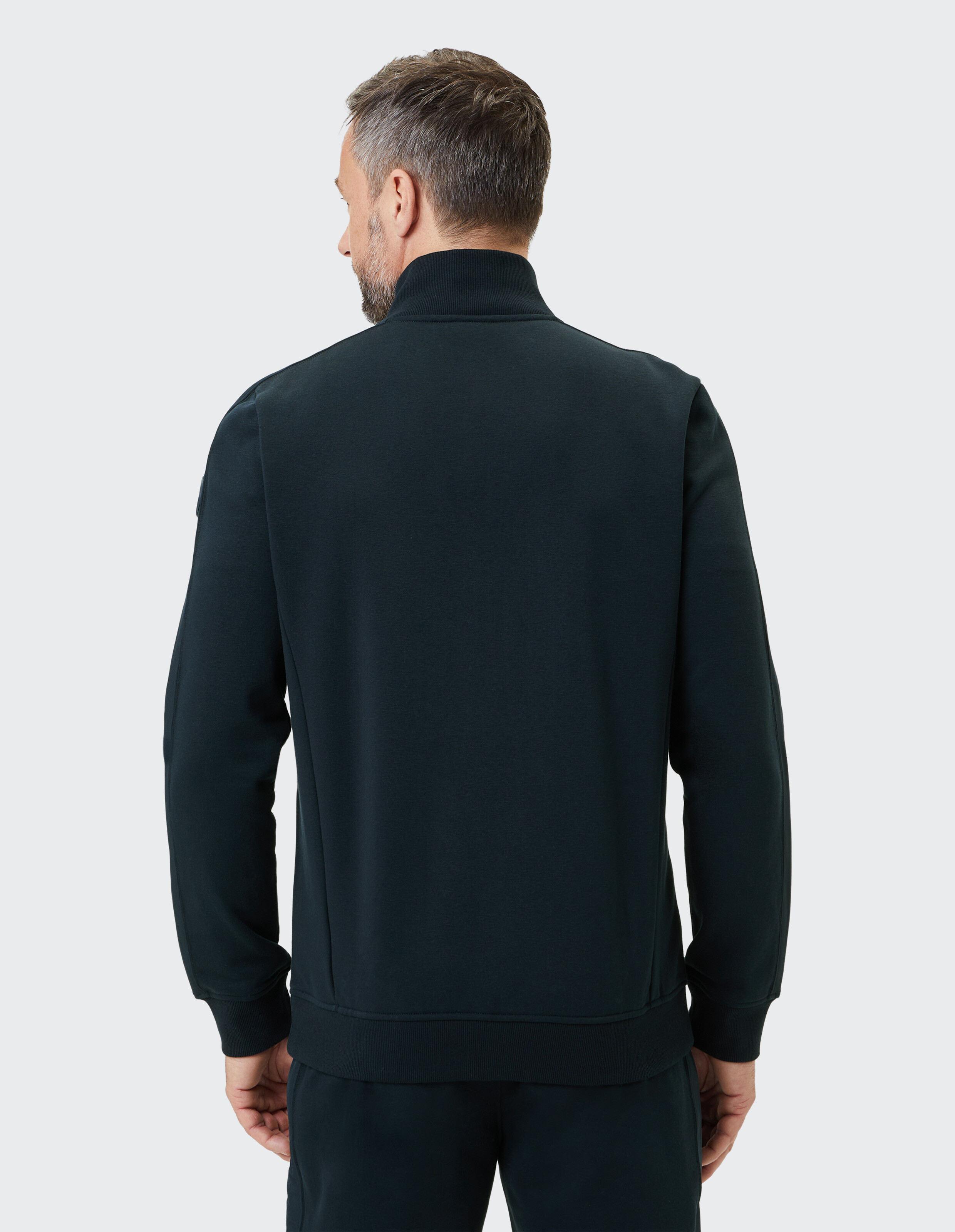 Mann trägt ein dunkelgrünes, lässiges Sweatshirt mit Reißverschluss und Stehkragen.