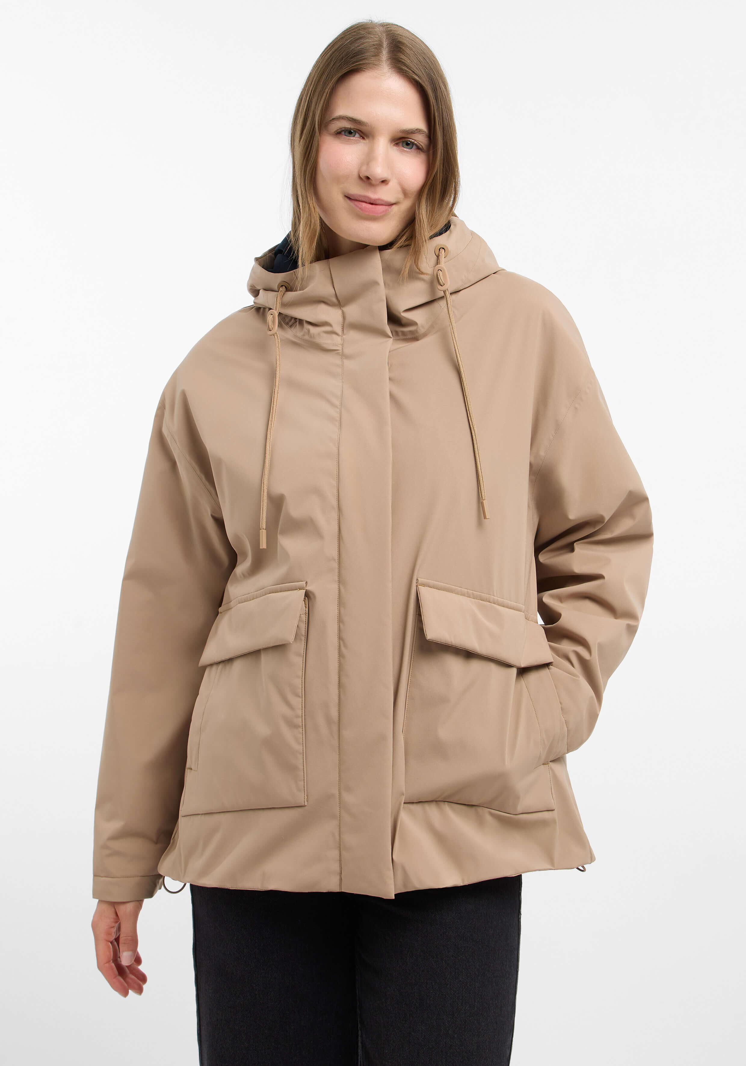 Frau trägt eine beige Freizeitjacke mit Kapuze und großen Pattentaschen für den Alltag.