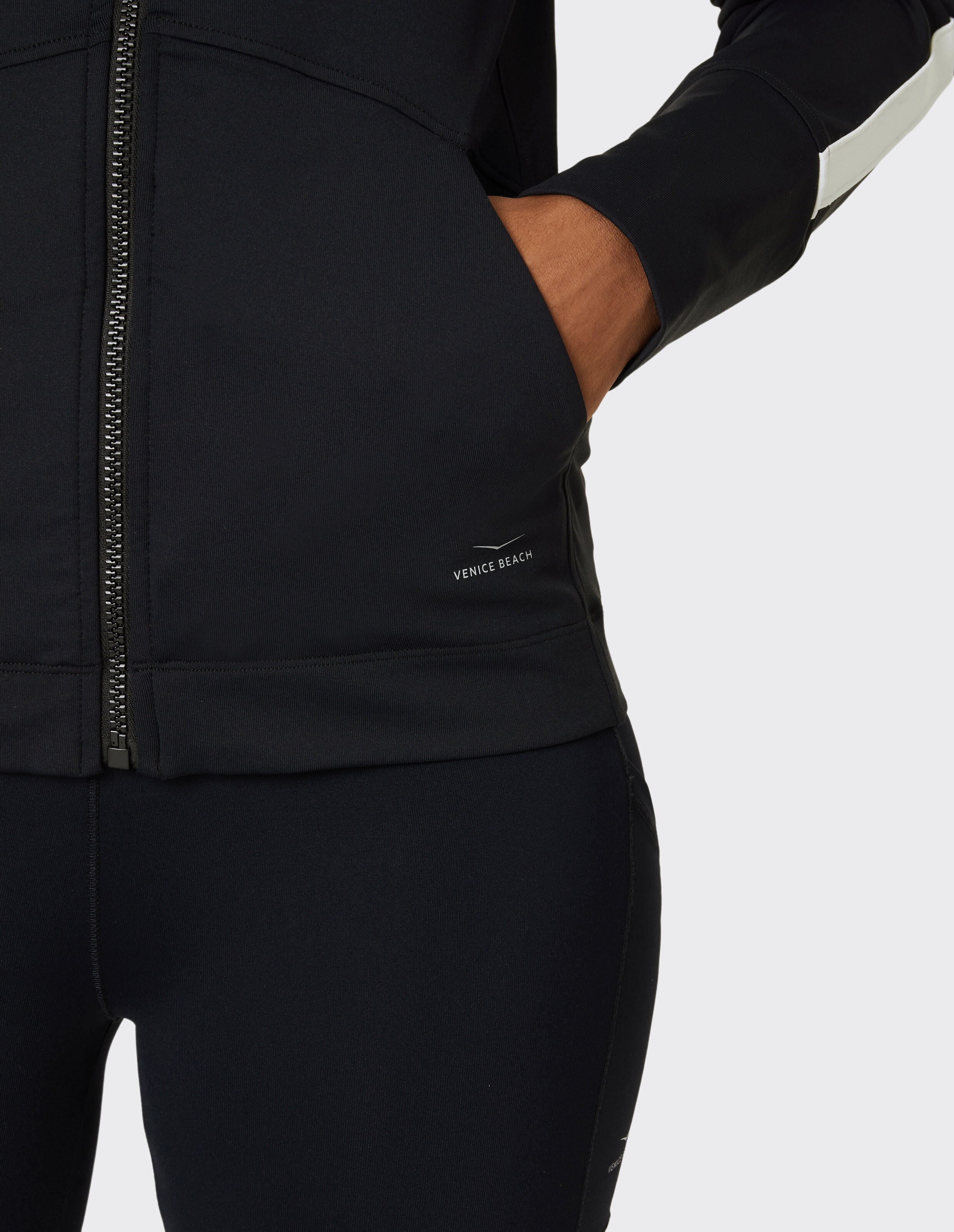 Nahaufnahme einer schwarzen Freizeitjacke mit Reißverschluss und Venice Beach-Branding.