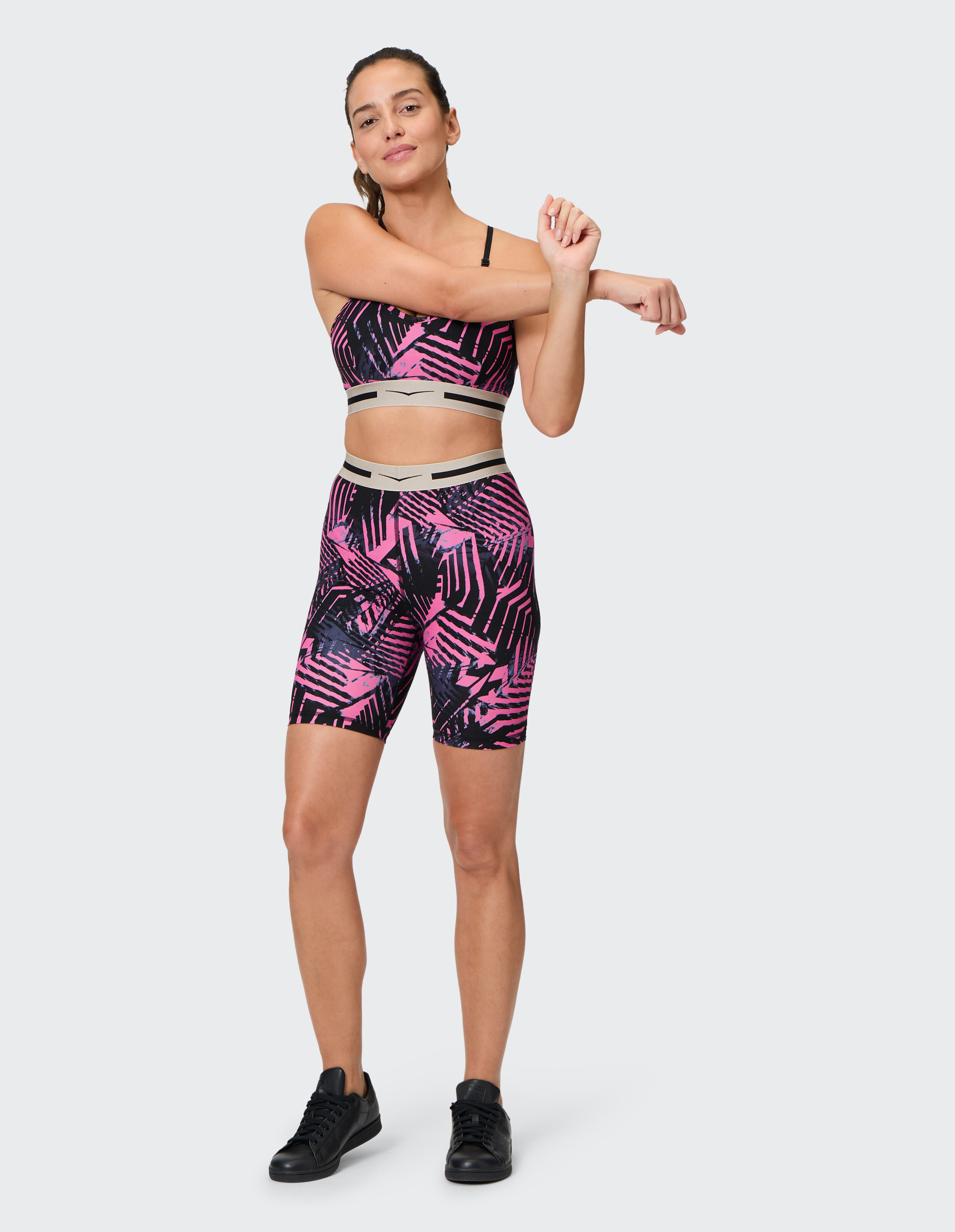 Frau trägt die Shorts „Venice Beach Jasmine“ mit rosa-schwarzem Palmenblatt-Print.