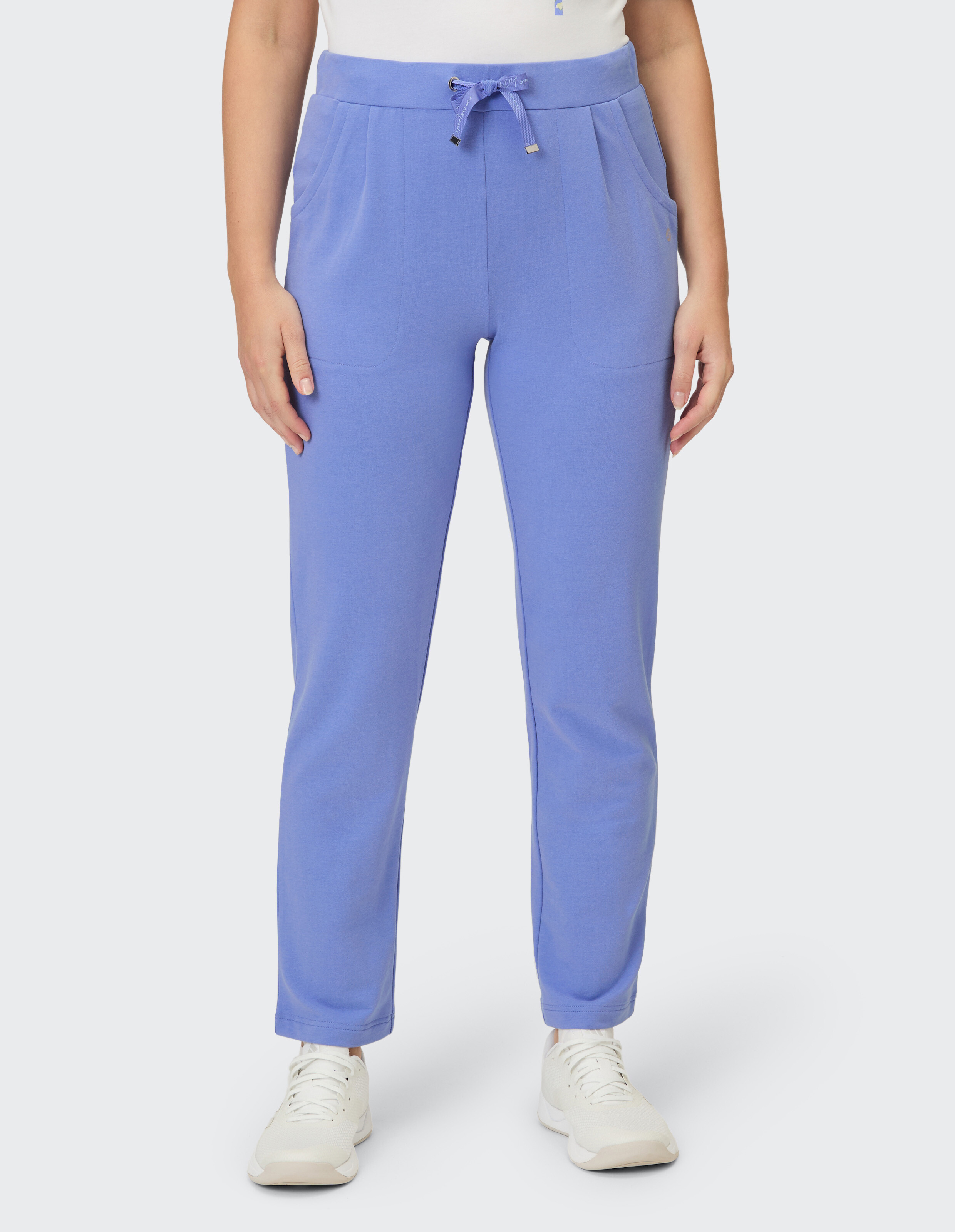 Eine Person trägt eine hellviolette Hose mit Kordelzug und Taschen.