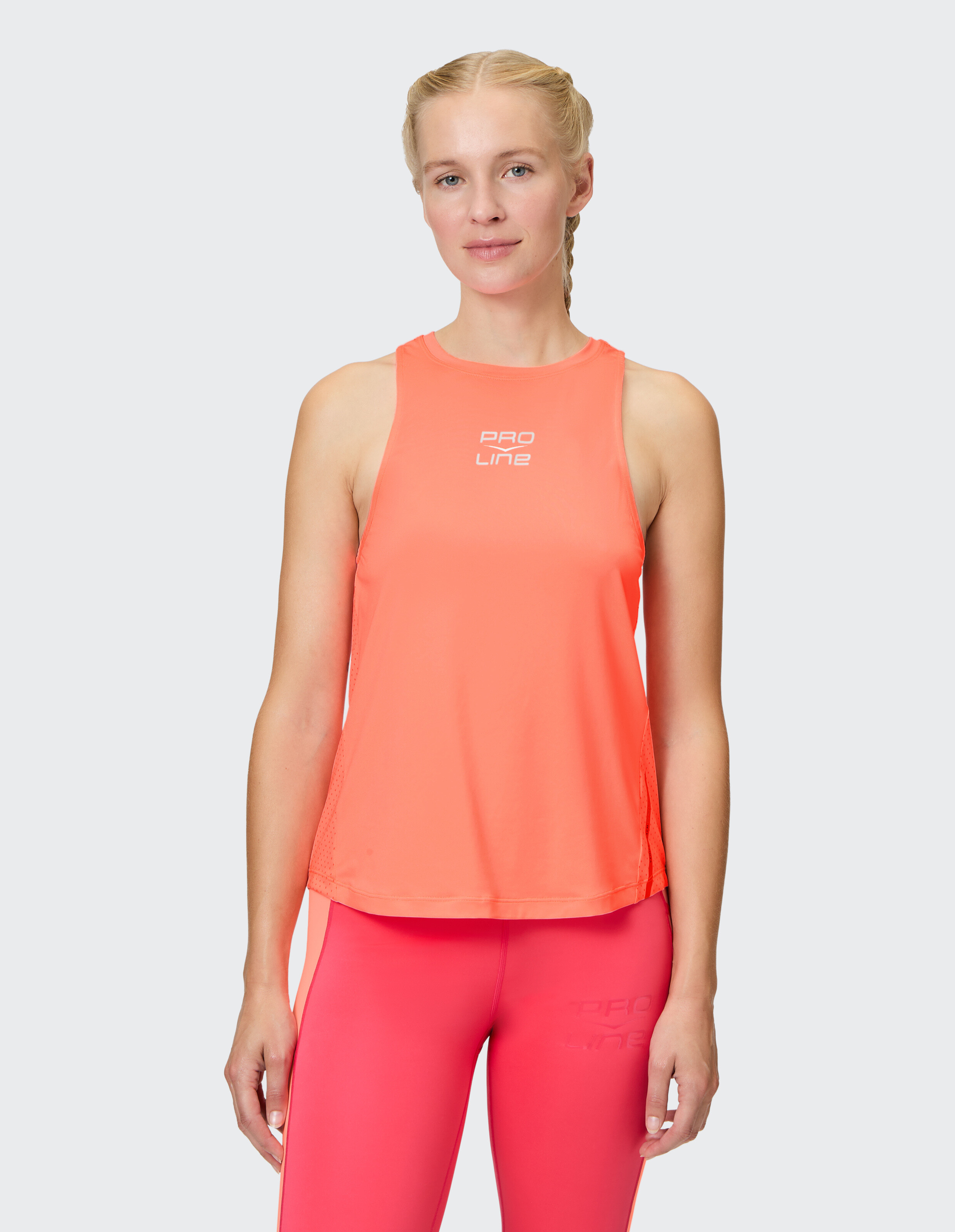 Frau trägt ein leuchtend orangefarbenes, ärmelloses Sport-Tanktop für sportliche Freizeitkleidung.