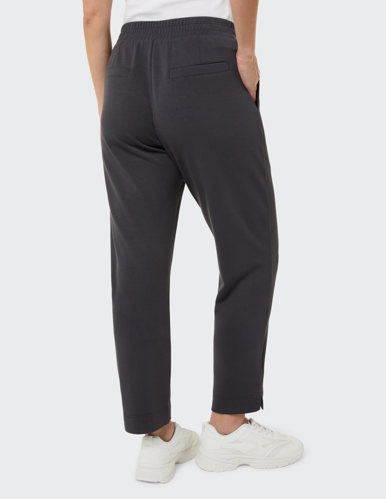 Rückansicht einer dunkelgrauen Freizeithose für Damen mit elastischem Bund und Taschen.