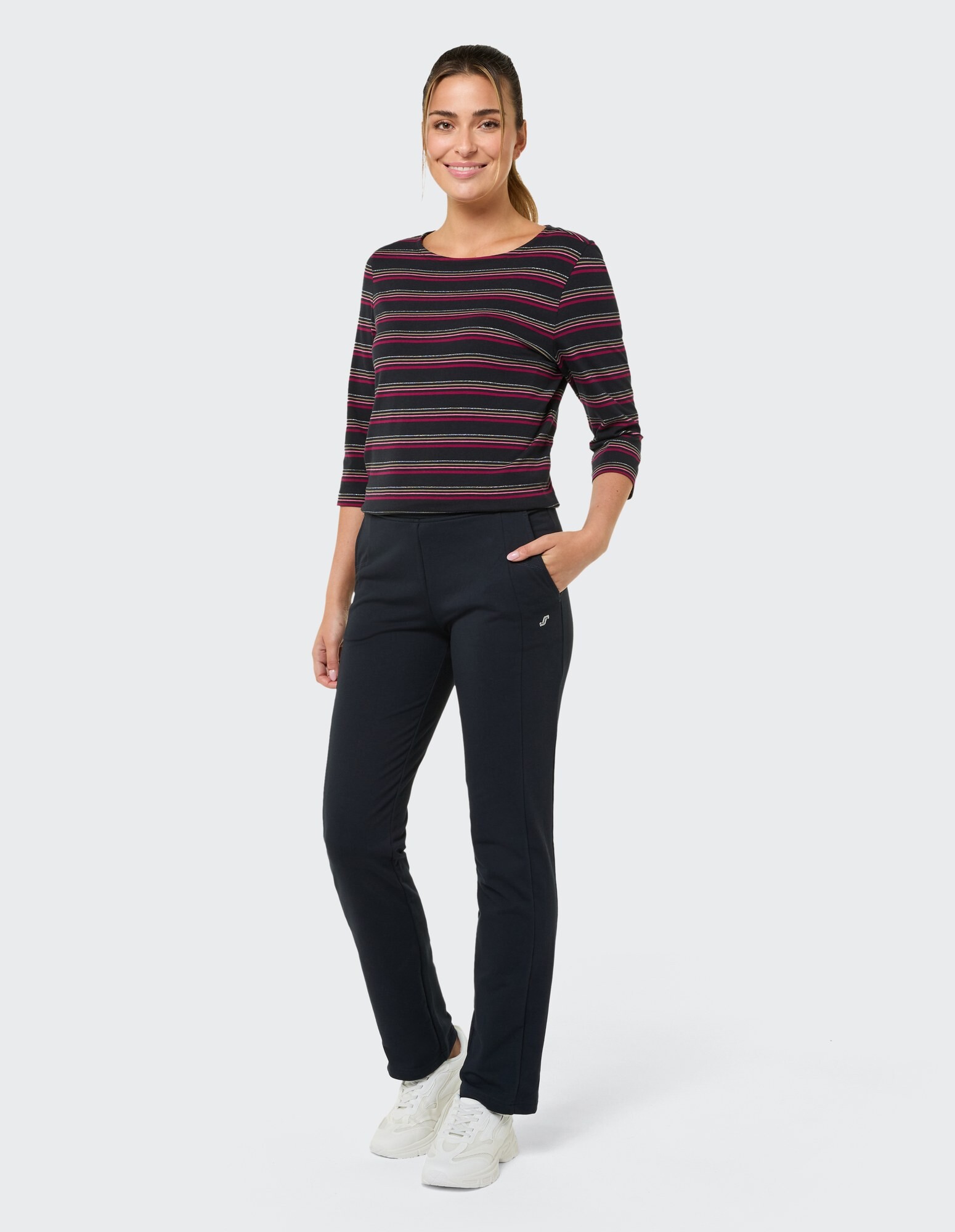 Frau in gestreiftem Langarmshirt und schwarzer Hose, perfekt für Freizeitkleidung.