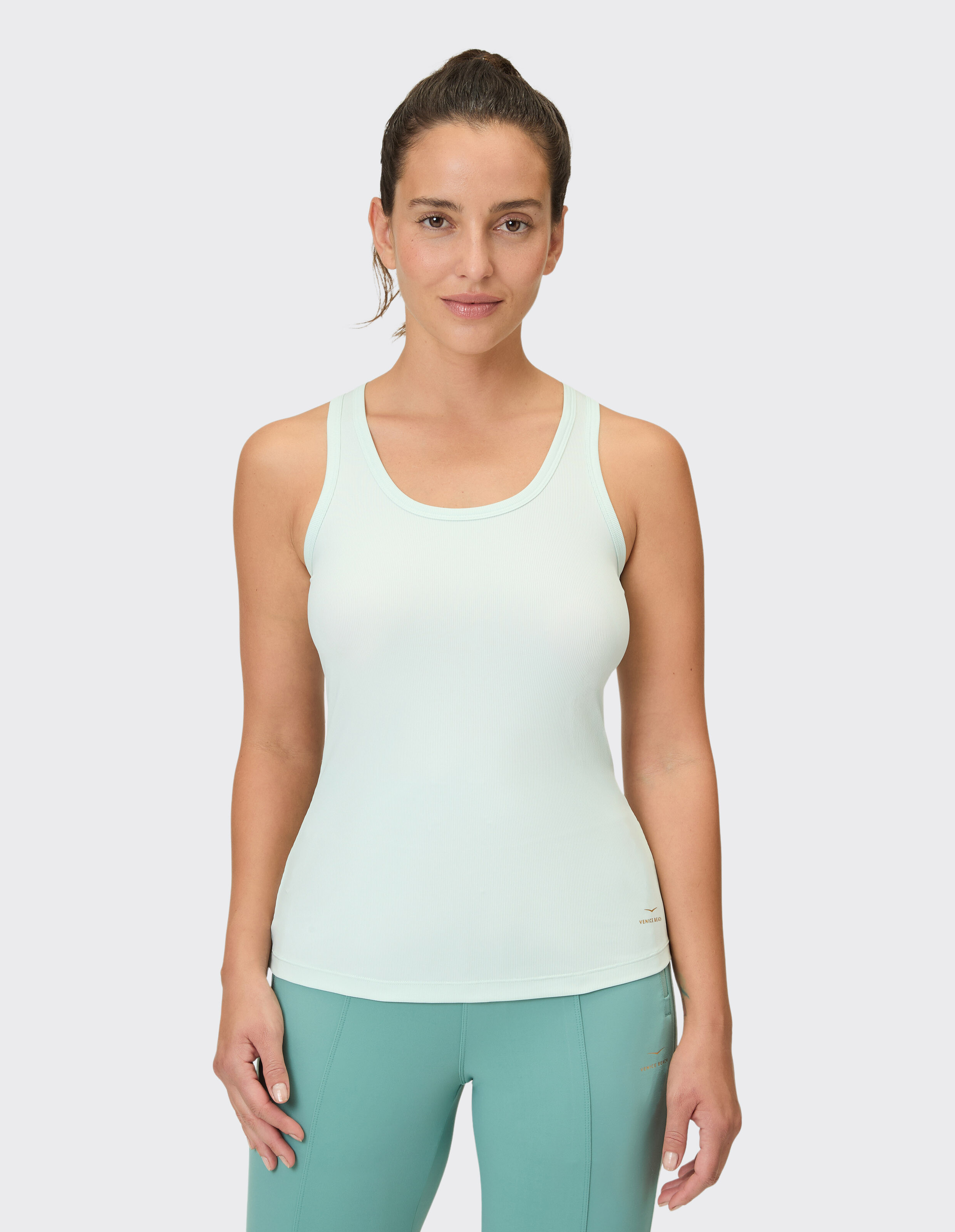 Frau trägt ein hellmintgrünes Tanktop, ideal für lässige Loungewear oder aktive Reisen.