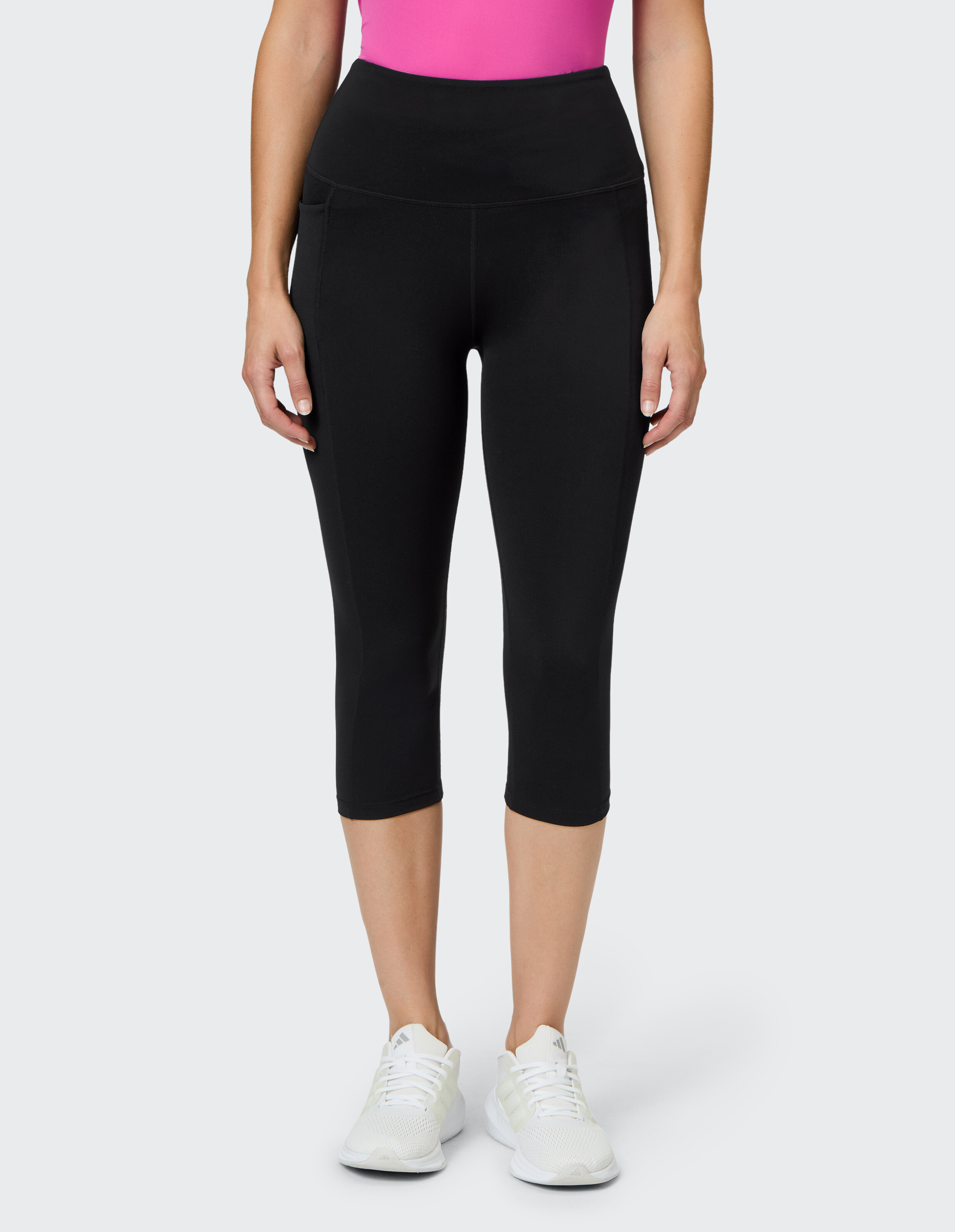 Frau trägt schwarze Capri-Leggings mit hoher Taille für lässige Aktivkleidung.