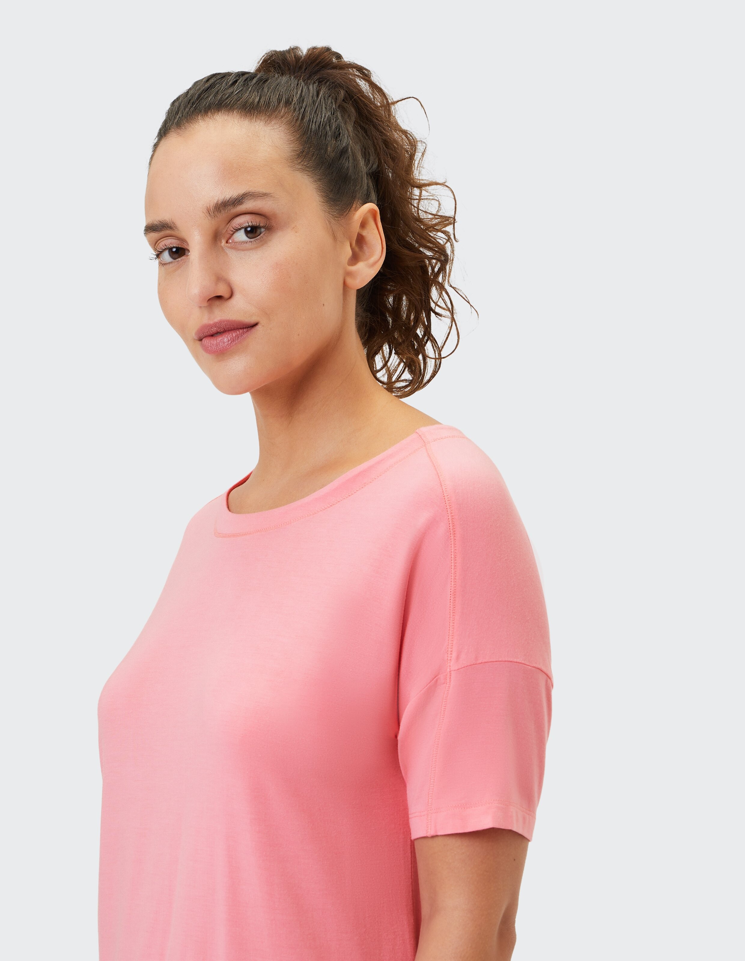 Frau trägt ein gemütliches, rosafarbenes Freizeit-T-Shirt für bequeme Alltags-Loungewear.