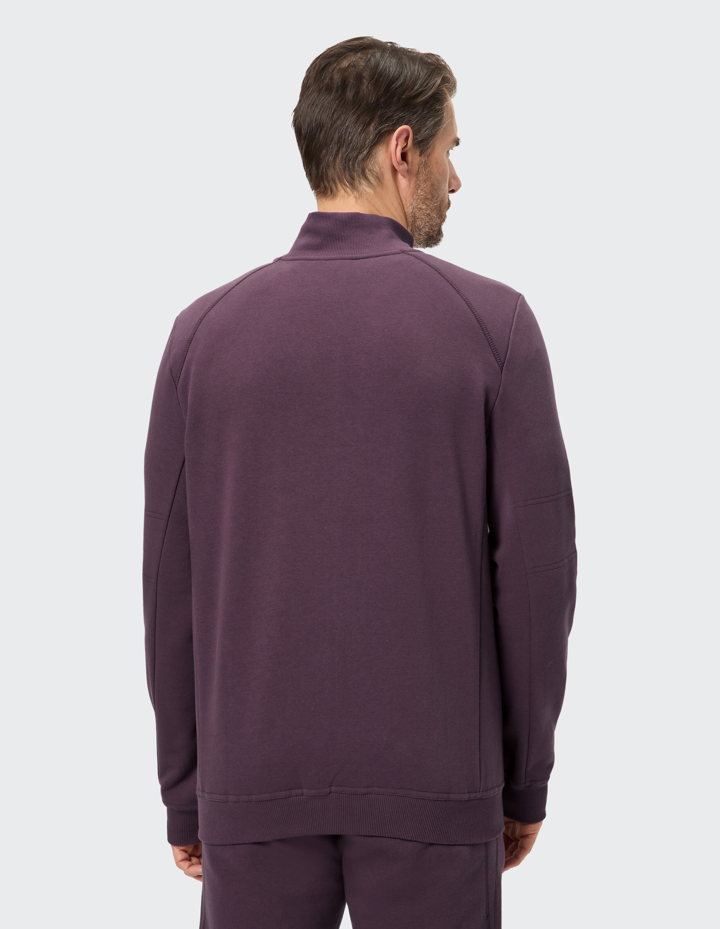 Rückansicht eines Mannes, der ein gemütliches lila Sweatshirt trägt, perfekt für Freizeitkleidung.
