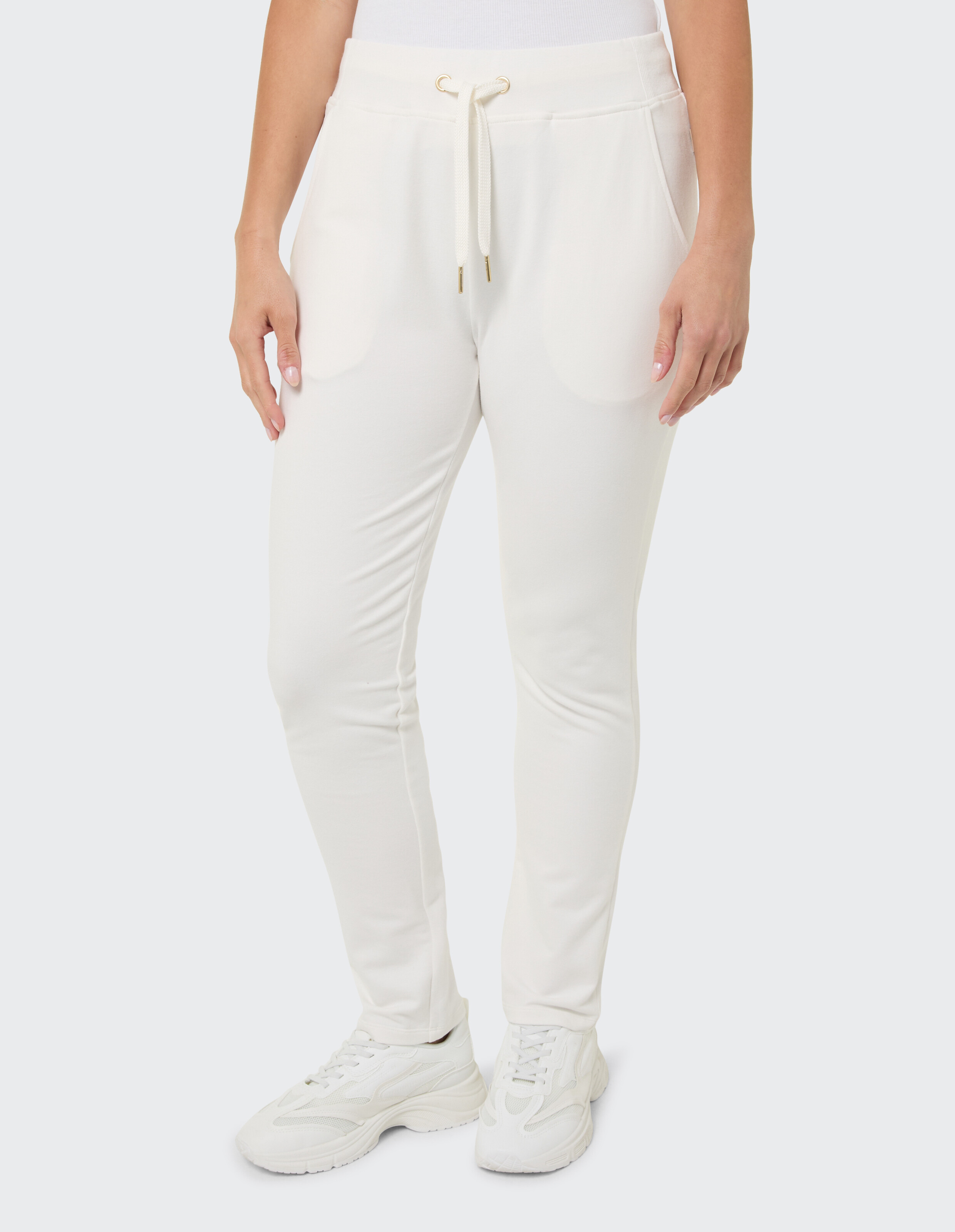 Frau trägt weiße, lässige Jogginghose mit Kordelzug in der Taille für bequeme Loungewear.