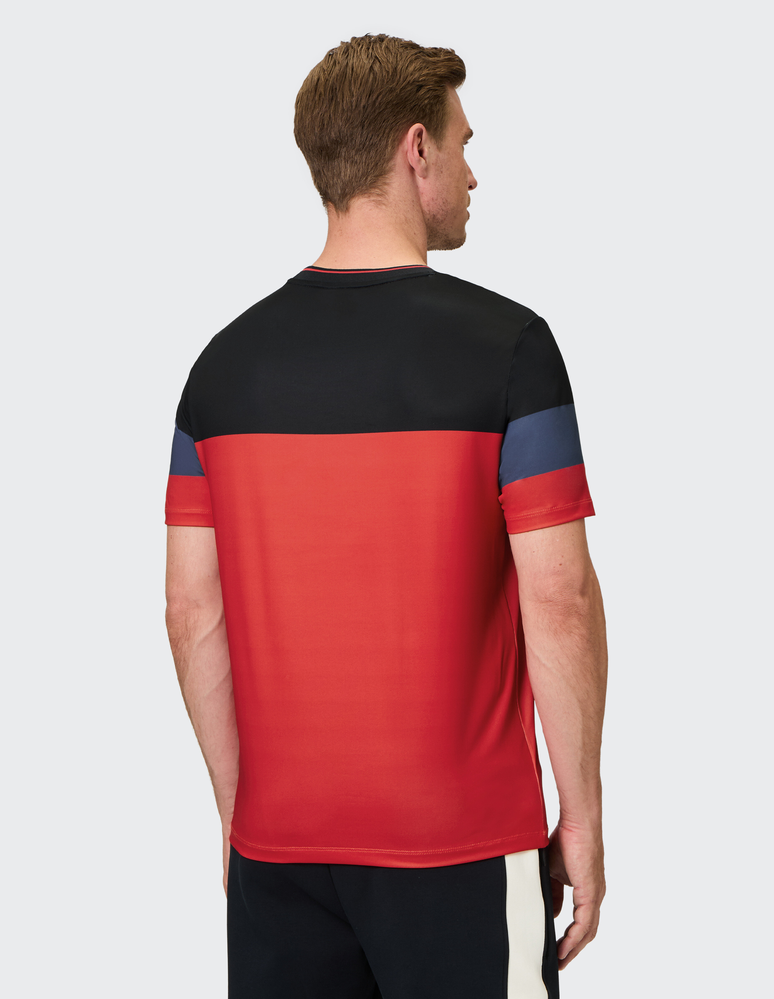 Kurzärmeliges T-Shirt mit schwarzem oberen Bereich, rotem Mittelteil, blauen und roten Streifen auf den Ärmeln, und Rundhalsausschnitt.
