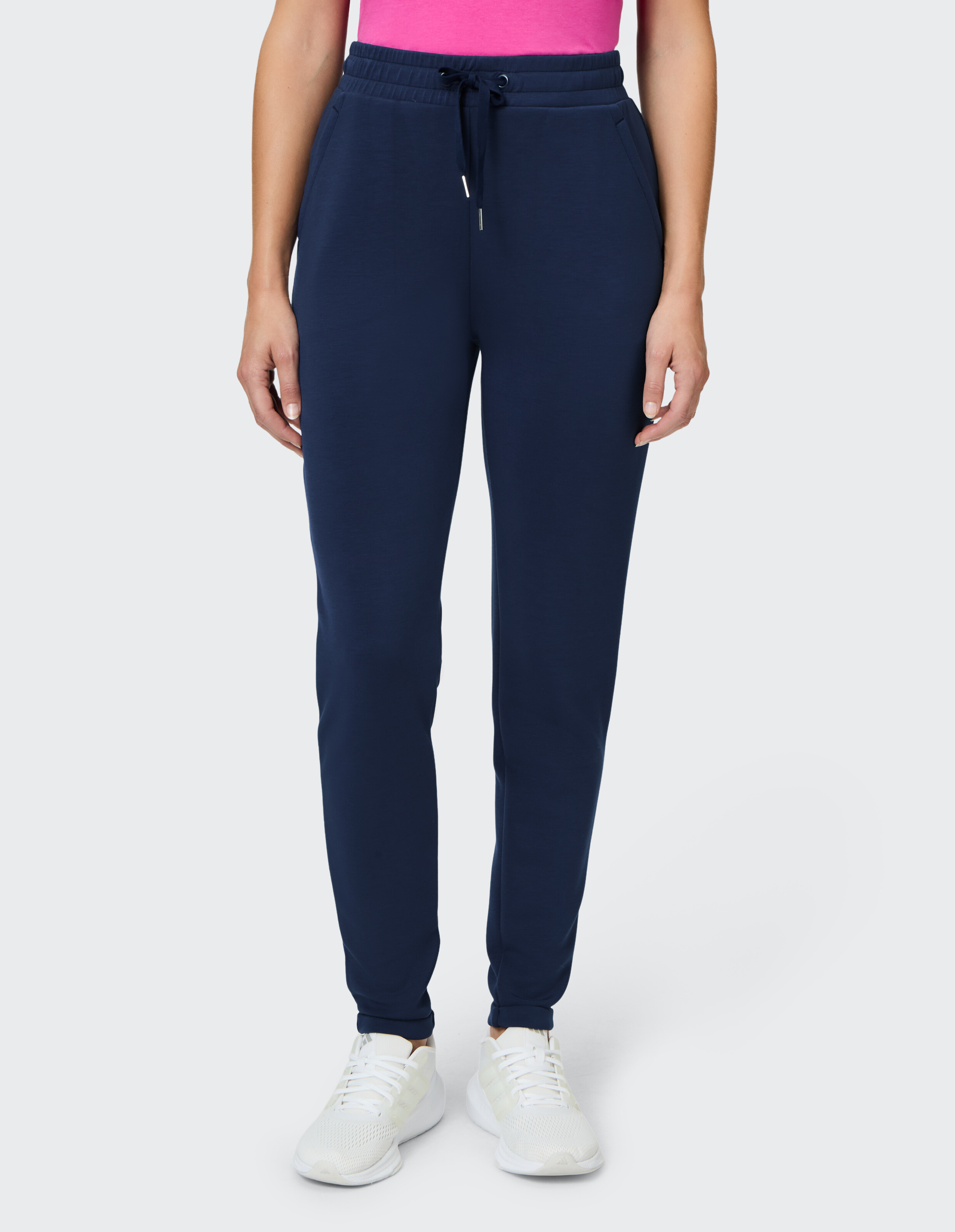 Marineblaue Jogginghose mit elastischem Bund, gepaart mit einem rosa Top und weißen Sneakers.