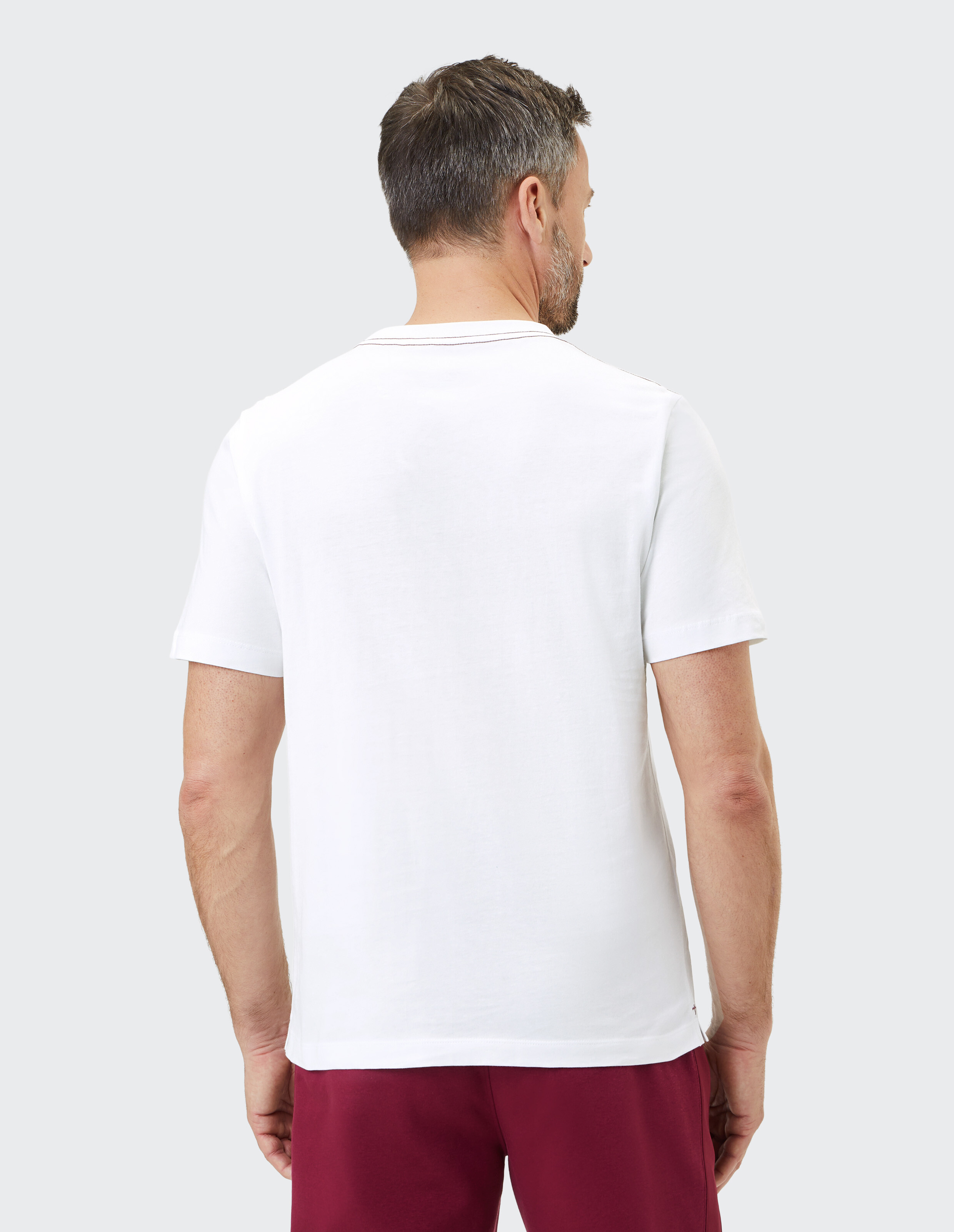 Mann trägt ein klassisches weißes Freizeit-T-Shirt, Rückansicht, perfekt zum Faulenzen.