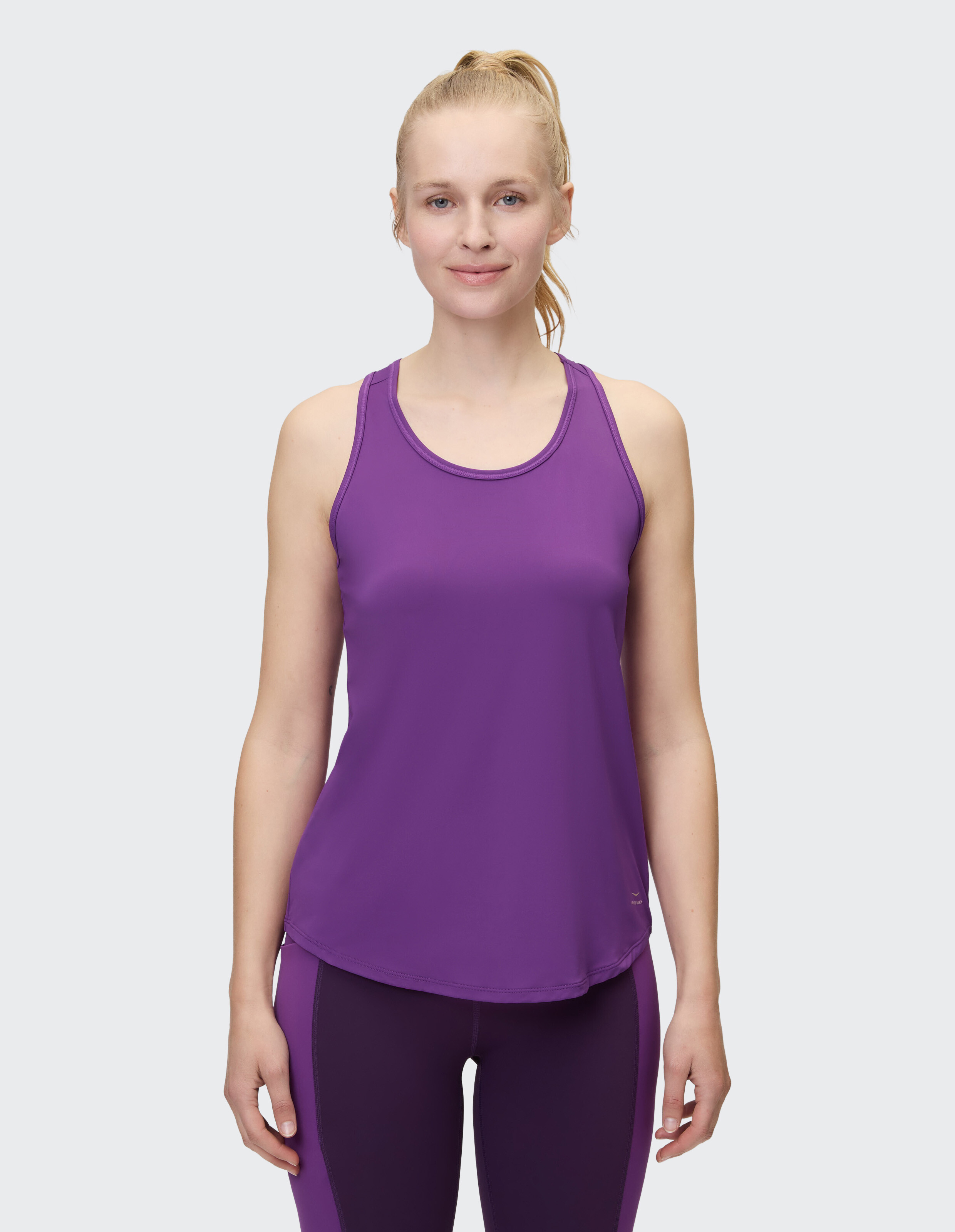 Frau trägt ein lila Racerback-Tanktop für lässige Sport- oder Loungekleidung.
