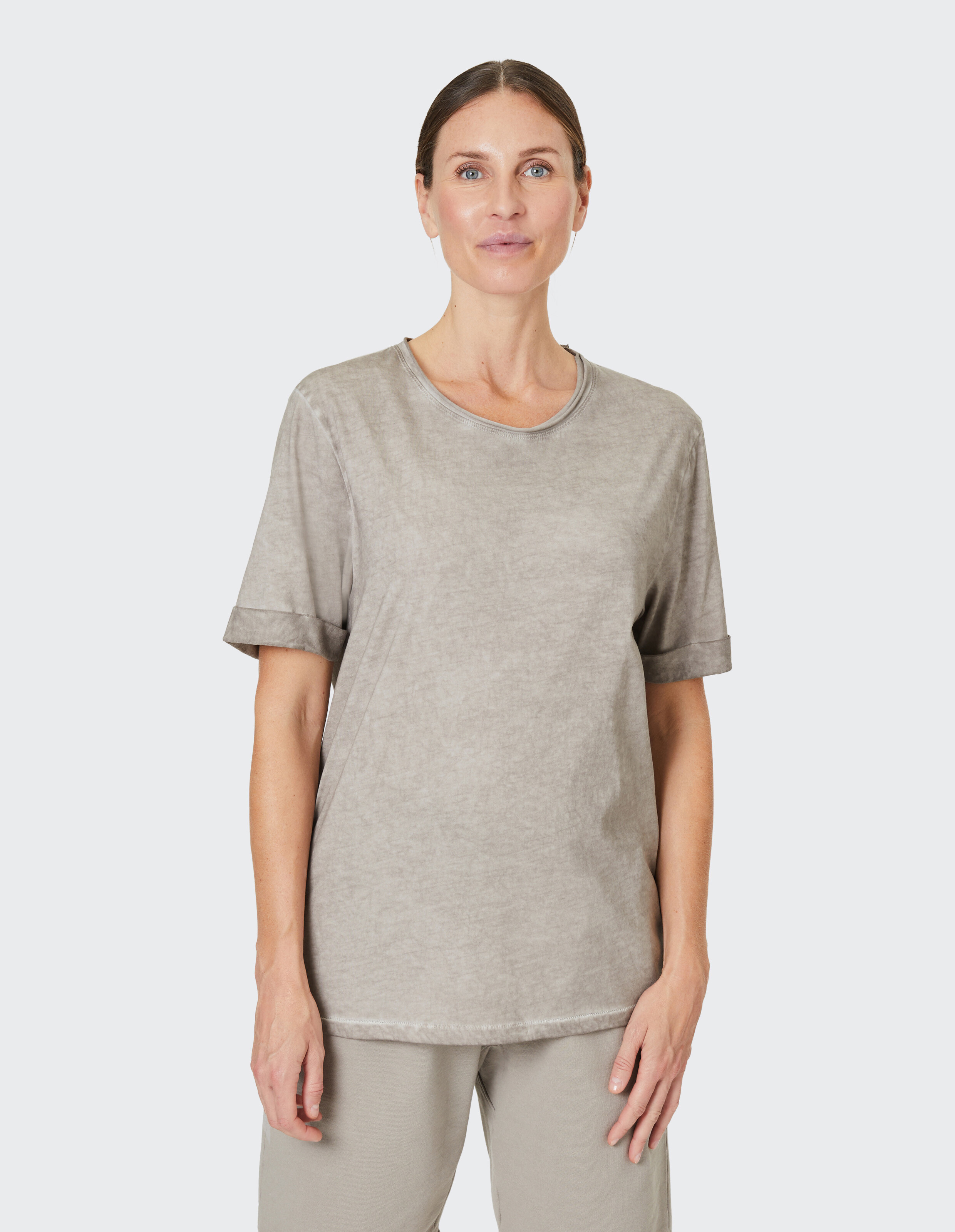 Lässiges hellgraues T-Shirt mit aufgerollten Ärmeln, perfekt für entspannte Ausflüge.