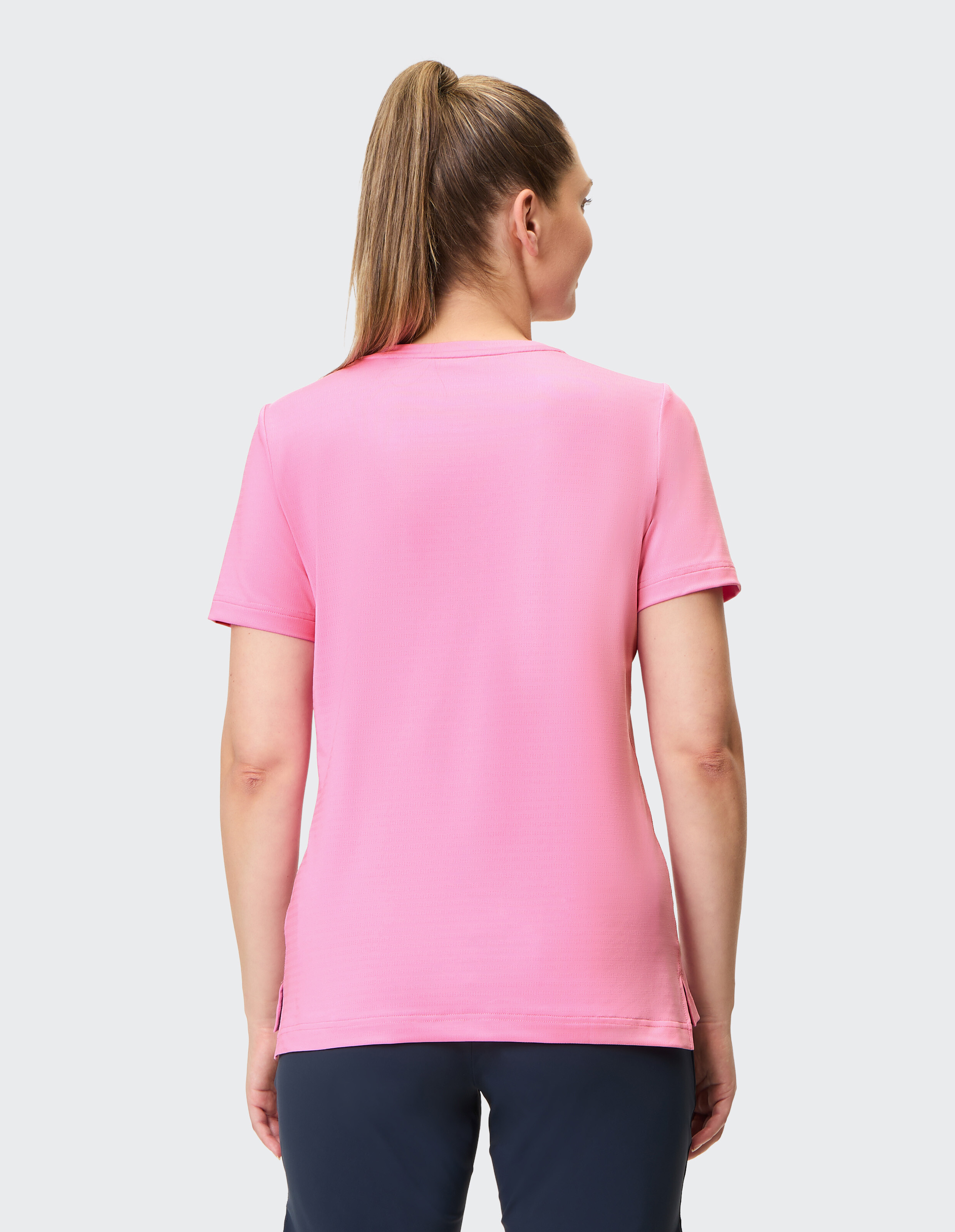 Rückansicht einer Frau, die ein rosafarbenes Freizeit-T-Shirt trägt, ideal für entspannte Ausflüge.