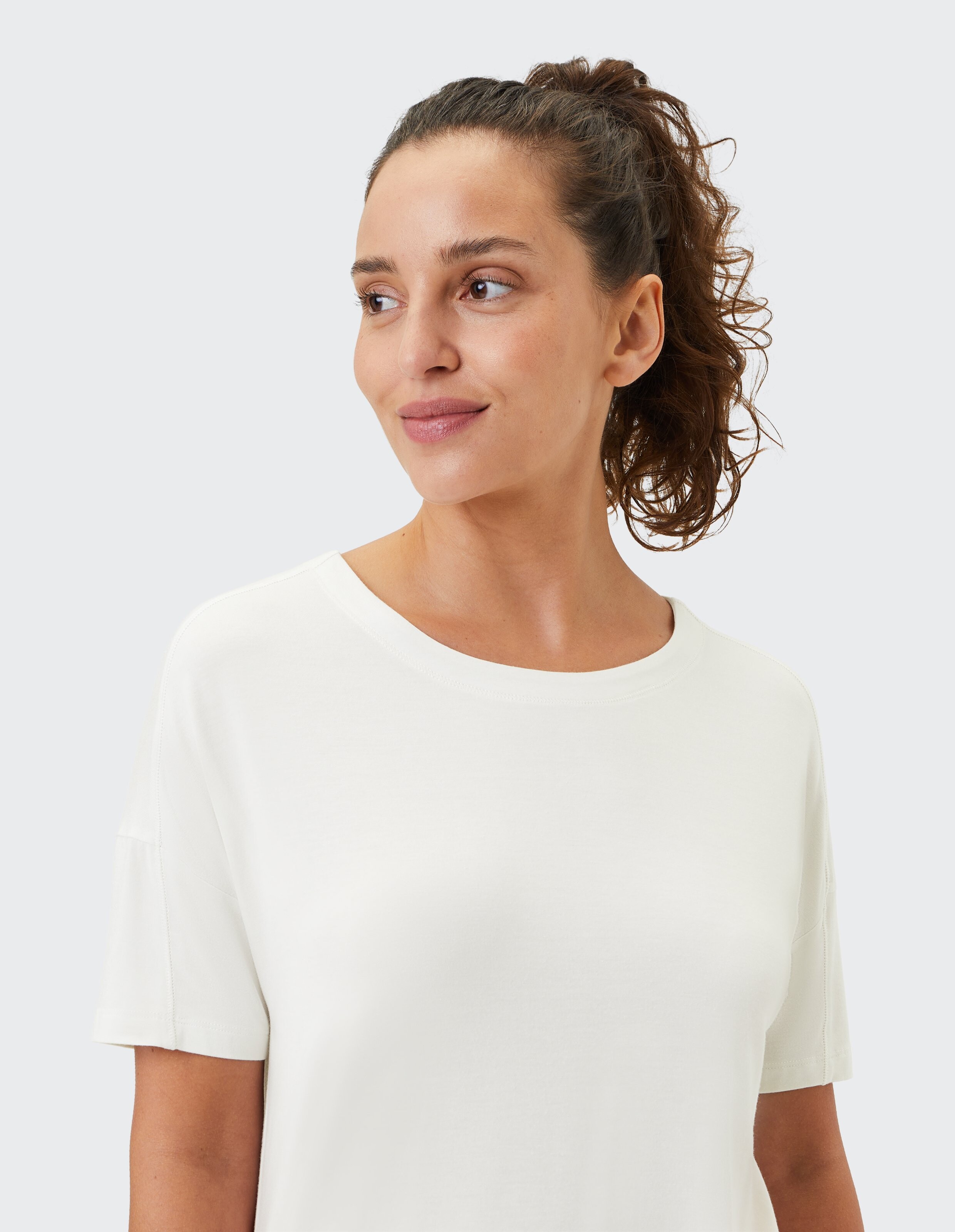 Frau in einem weichen weißen T-Shirt mit kurzen Ärmeln, perfekt für Freizeitkleidung.