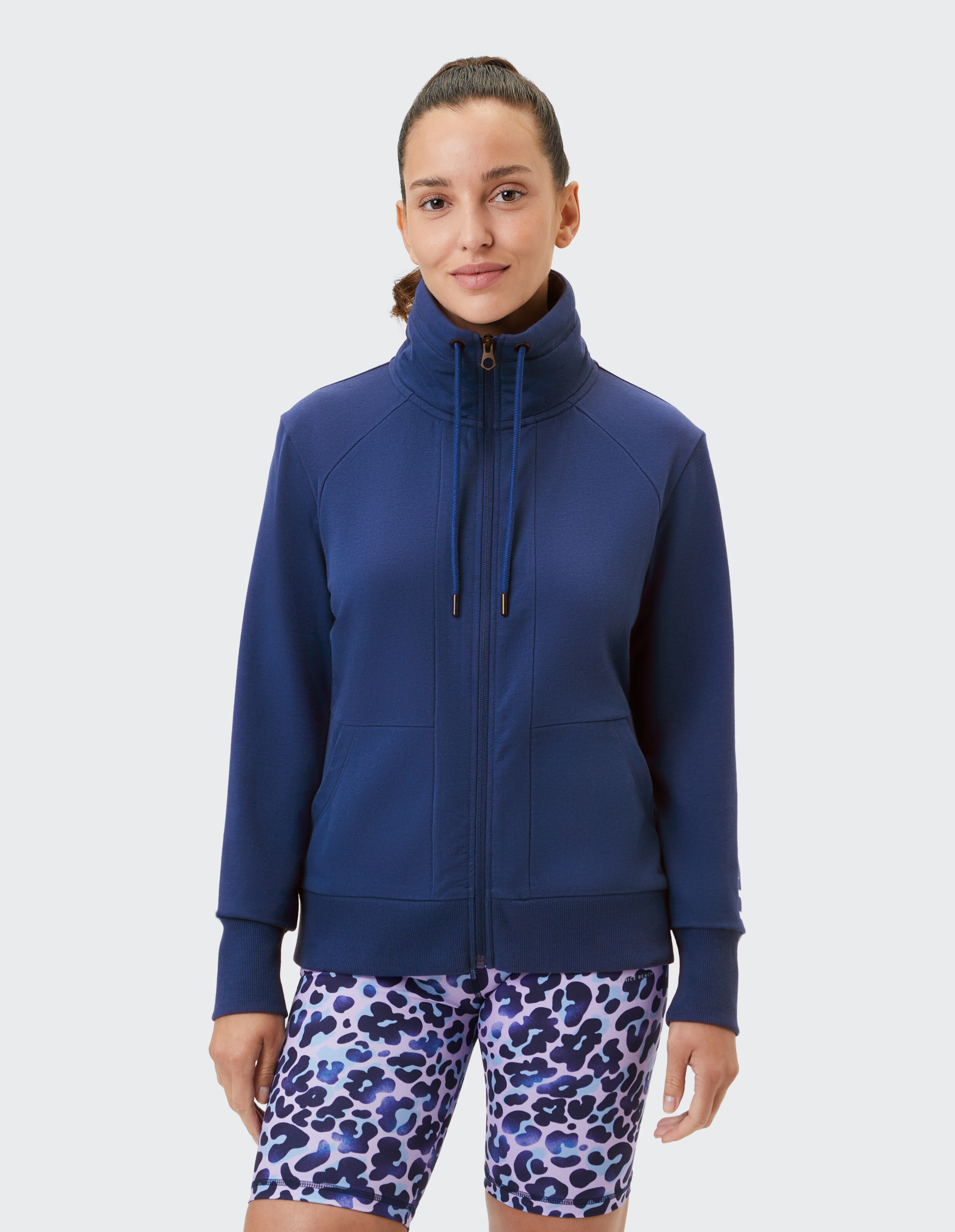 Frau trägt ein gemütliches marineblaues Sweatshirt mit Reißverschluss und hohem Kragen für lässigen Stil.