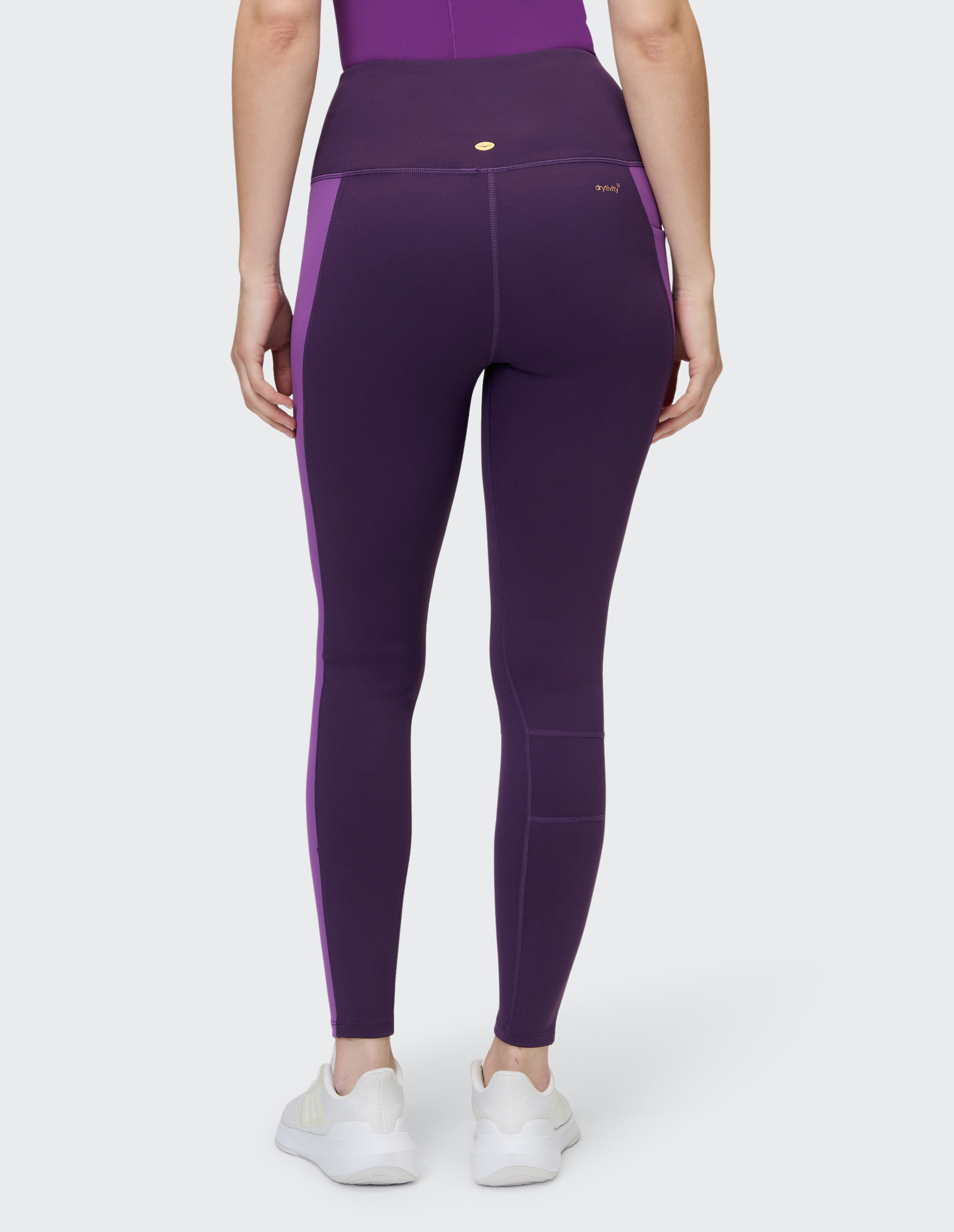 Rückansicht einer lila Leggings mit hoher Taille und Seiteneinsätzen für lässige Sportbekleidung.