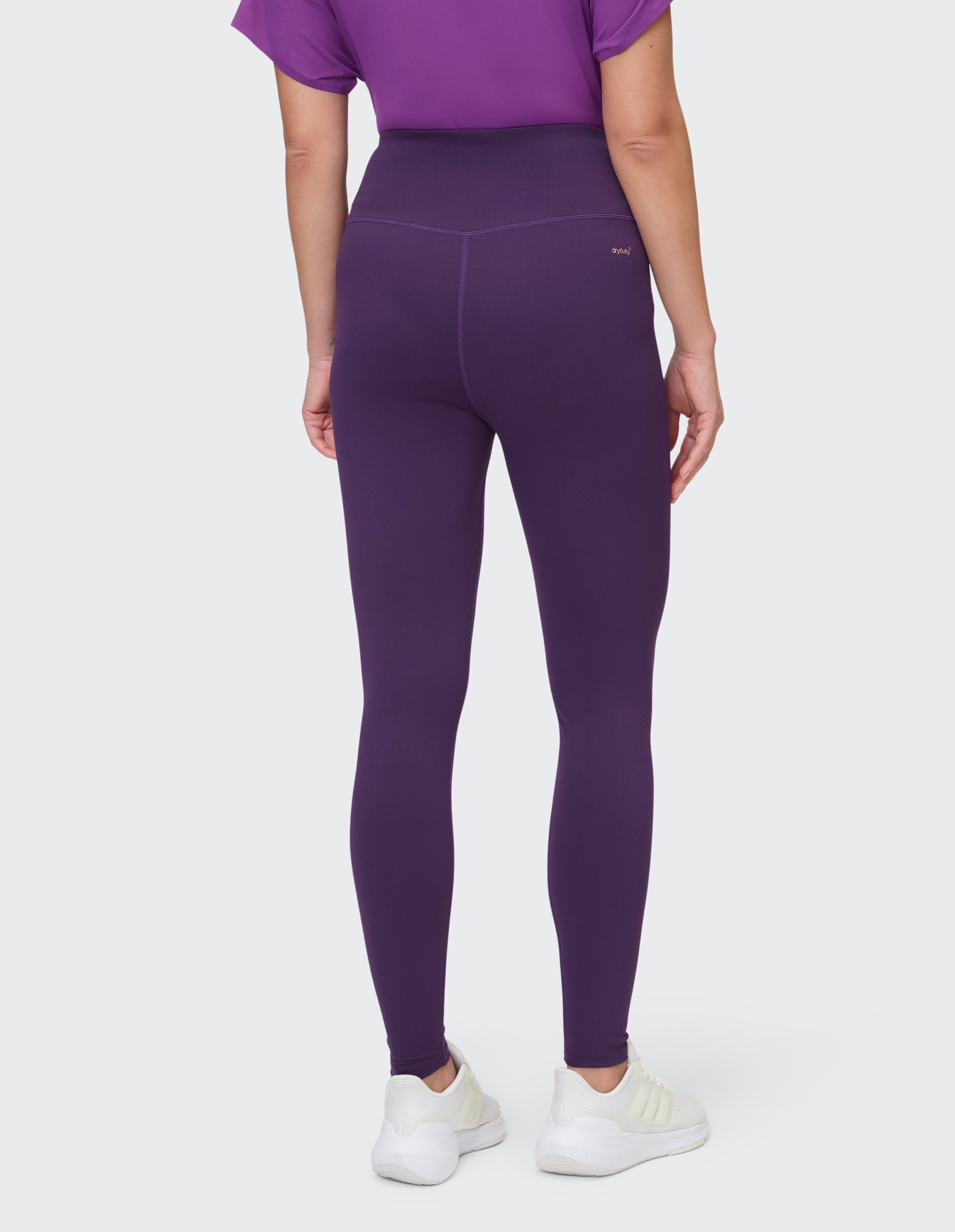 Rückansicht einer Frau, die lila Leggings mit hoher Taille für bequeme Freizeitkleidung trägt.
