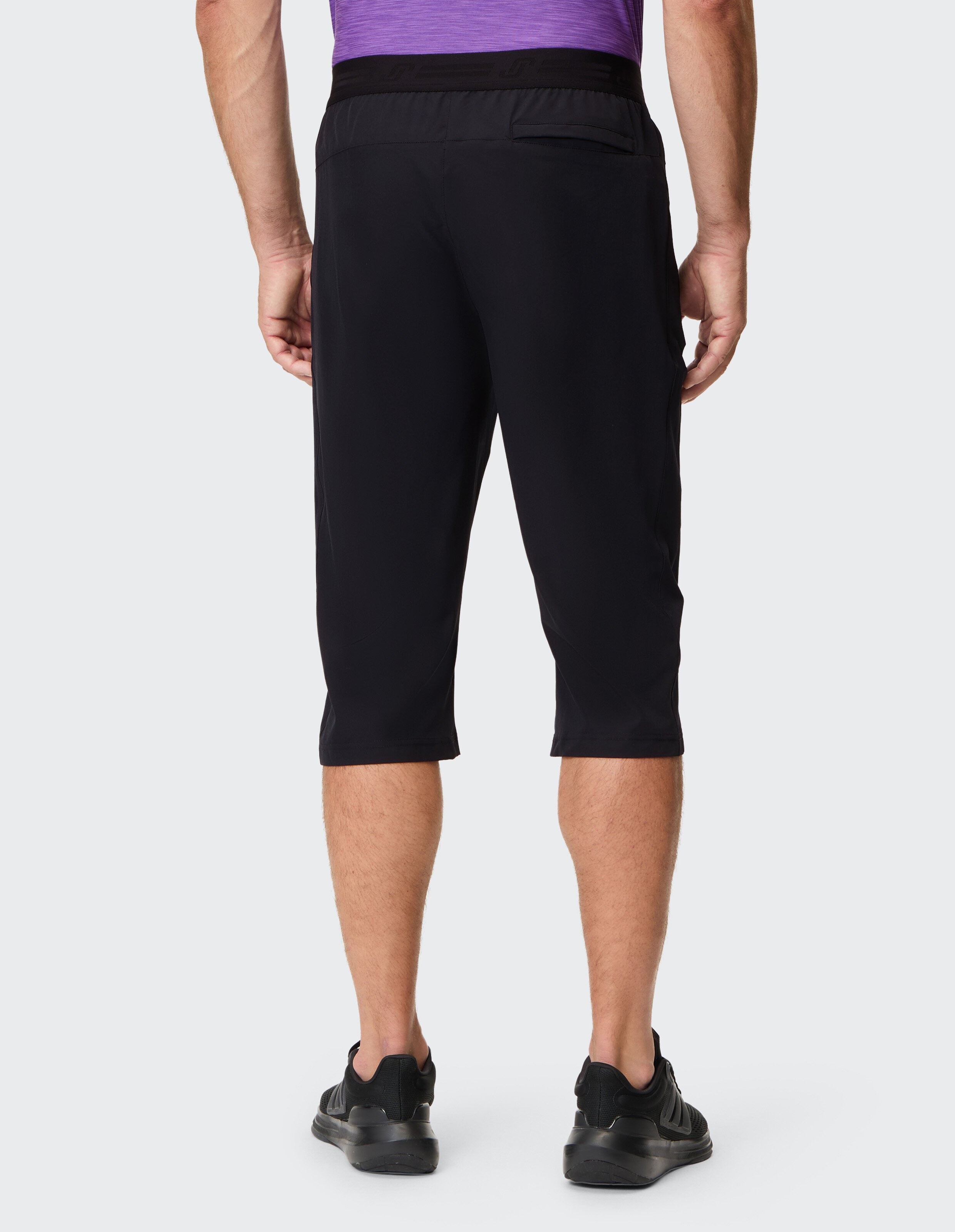 Rückansicht einer schwarzen, lässigen Capri-Shorts für Herren, perfekt für Aktiv- oder Lounge-Kleidung.