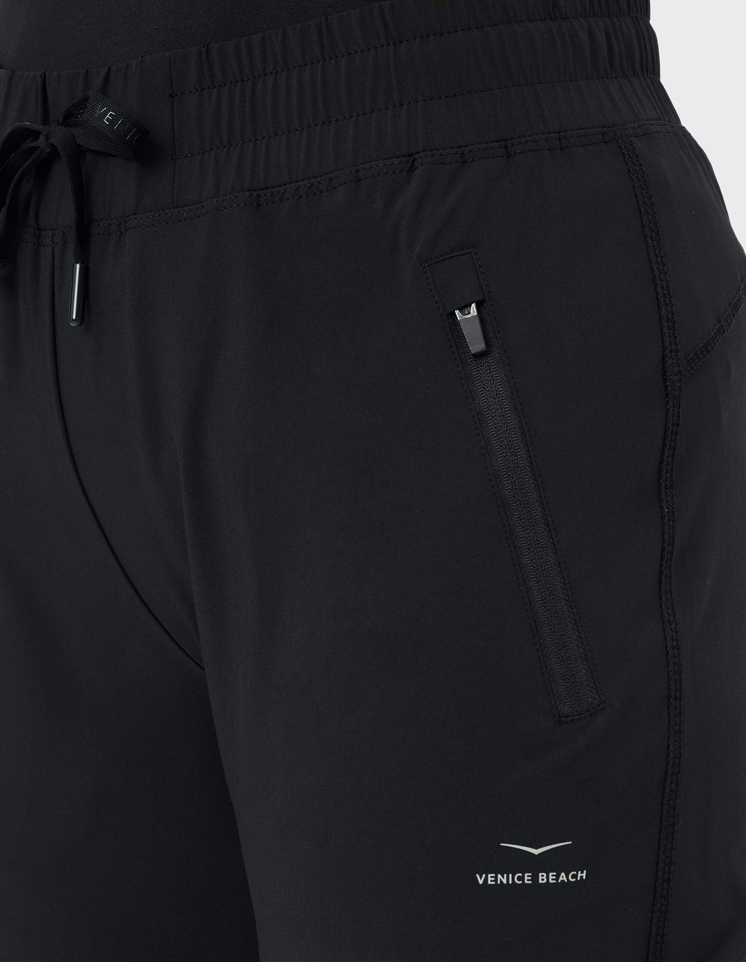 Nahaufnahme einer schwarzen Freizeitshorts mit elastischem Bund und seitlicher Reißverschlusstasche.